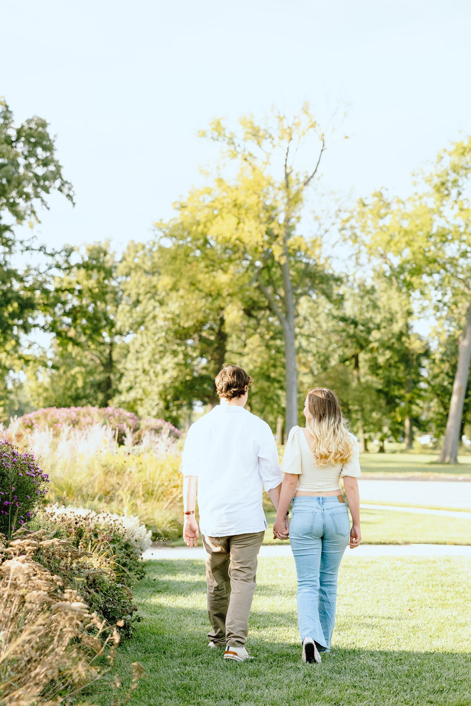 Engaged couple walking and holding hands at Belle Isle summer engagement session in Detroit, MI