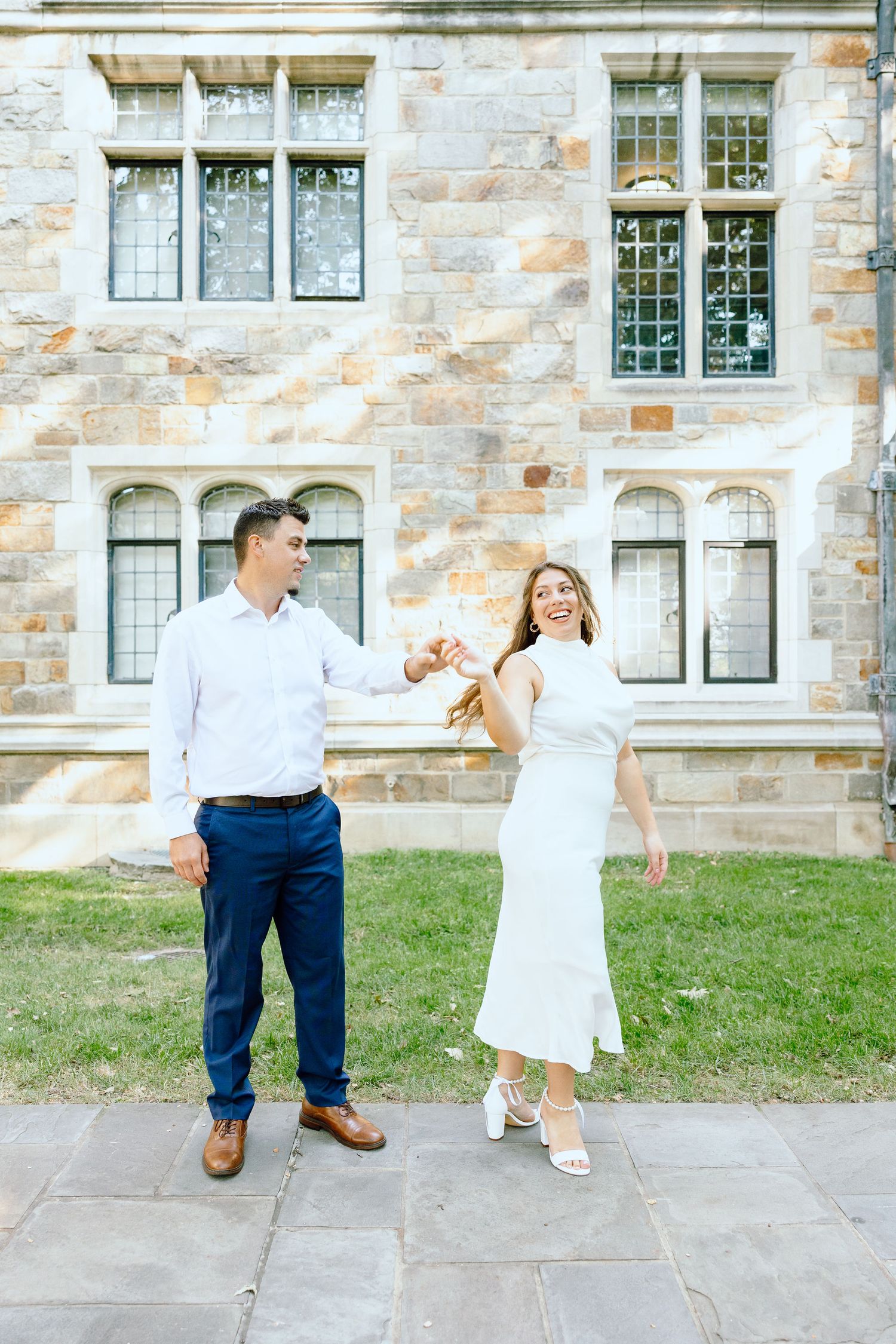 Engaged couple walking and holding hands at the UofM Law Quad engagement session in Ann Arbor, MI