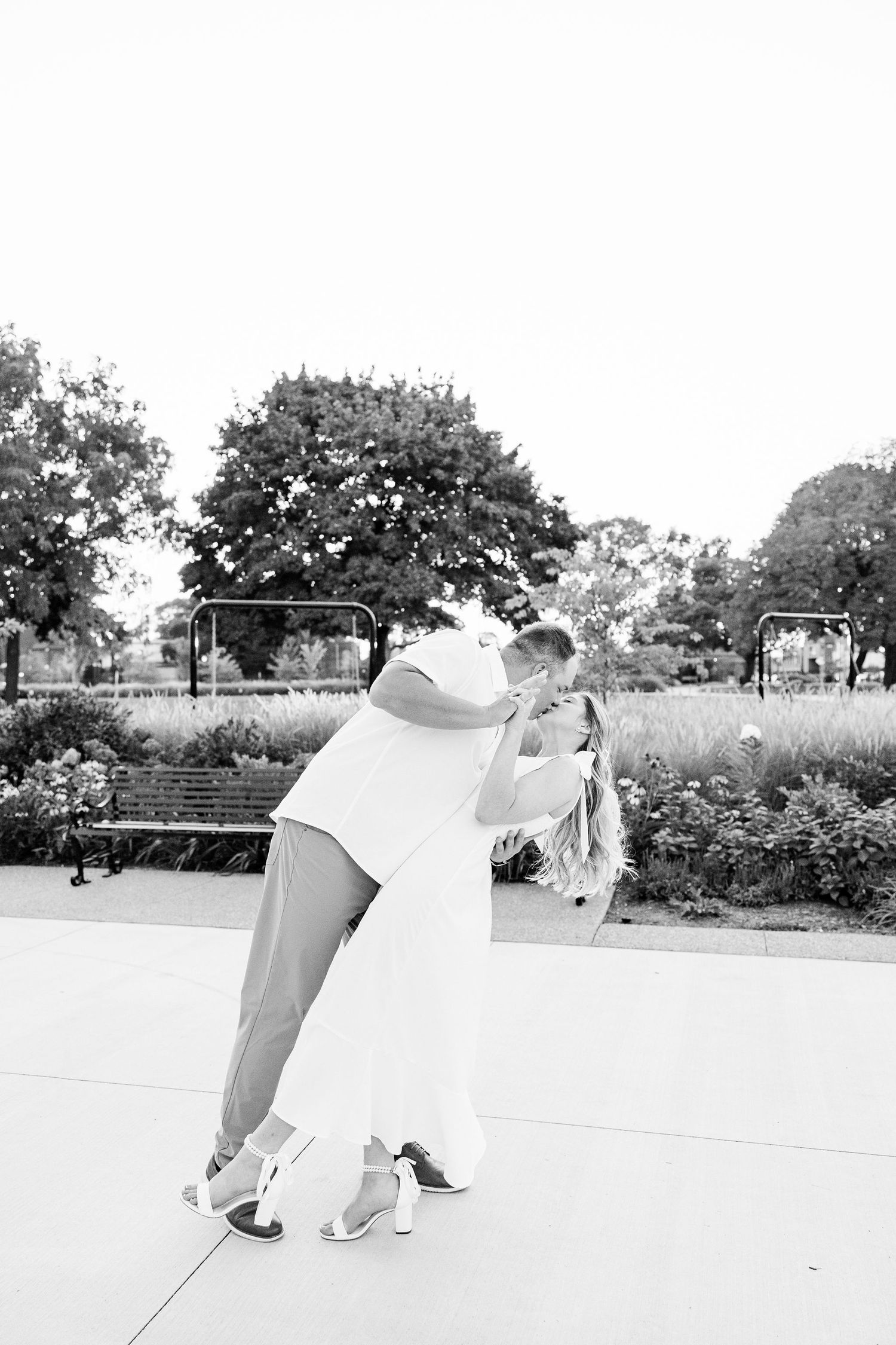 Engaged couple dipping and kissing at Michigan Central Station summer engagement session in Detroit, MI