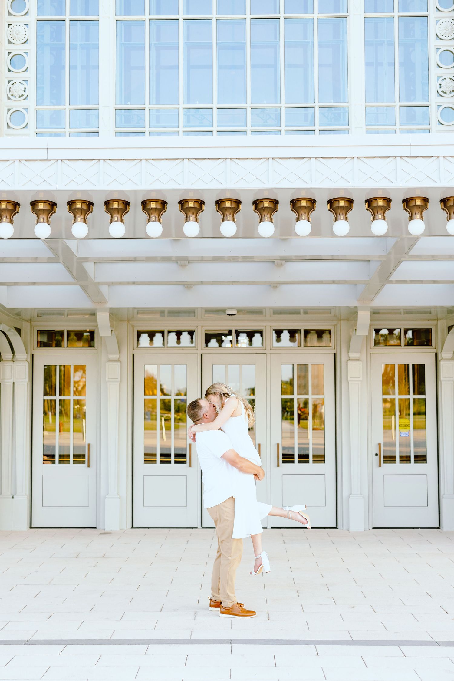 Man lifting woman at Michigan Central Station summer engagement session in Detroit, MI
