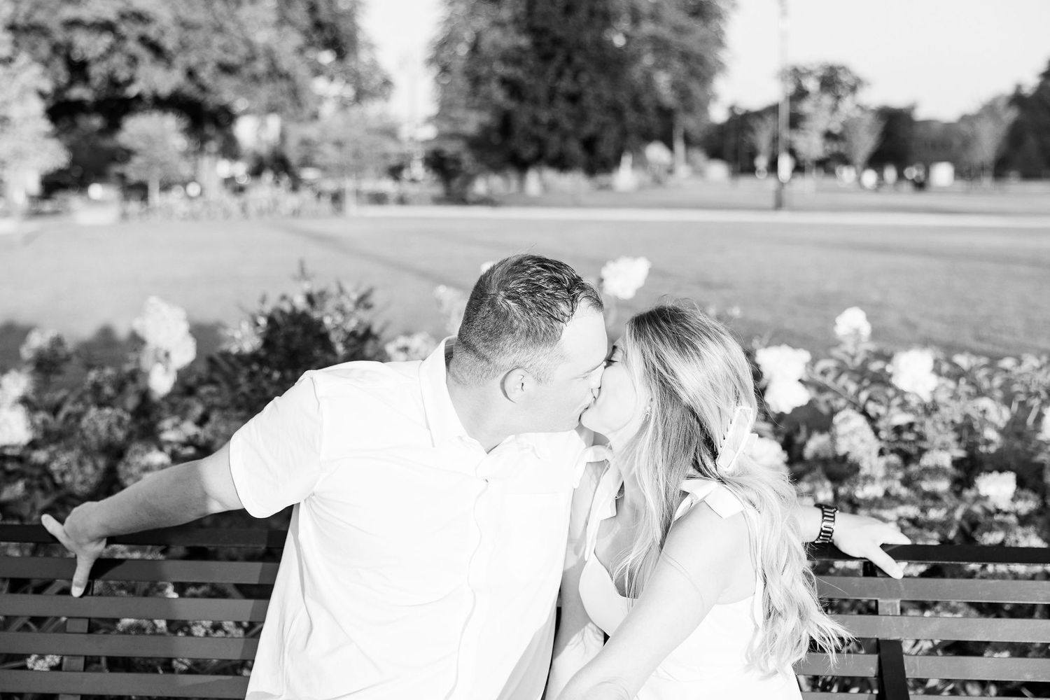 Engaged couple kissing on bench at Michigan Central Station in Detroit, MI