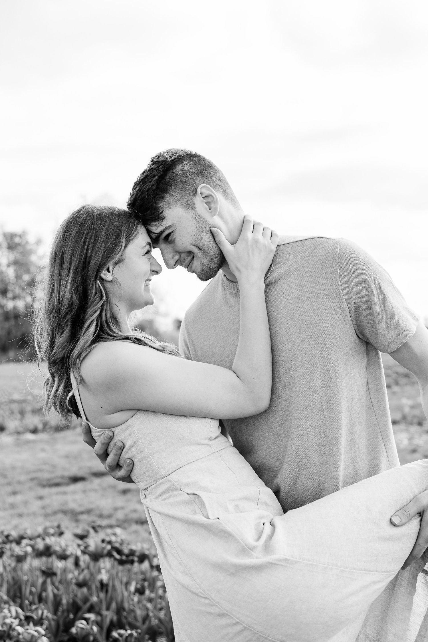 Engaged couple dipping at DeBuck's tulip field spring engagement session in Belleville, MI