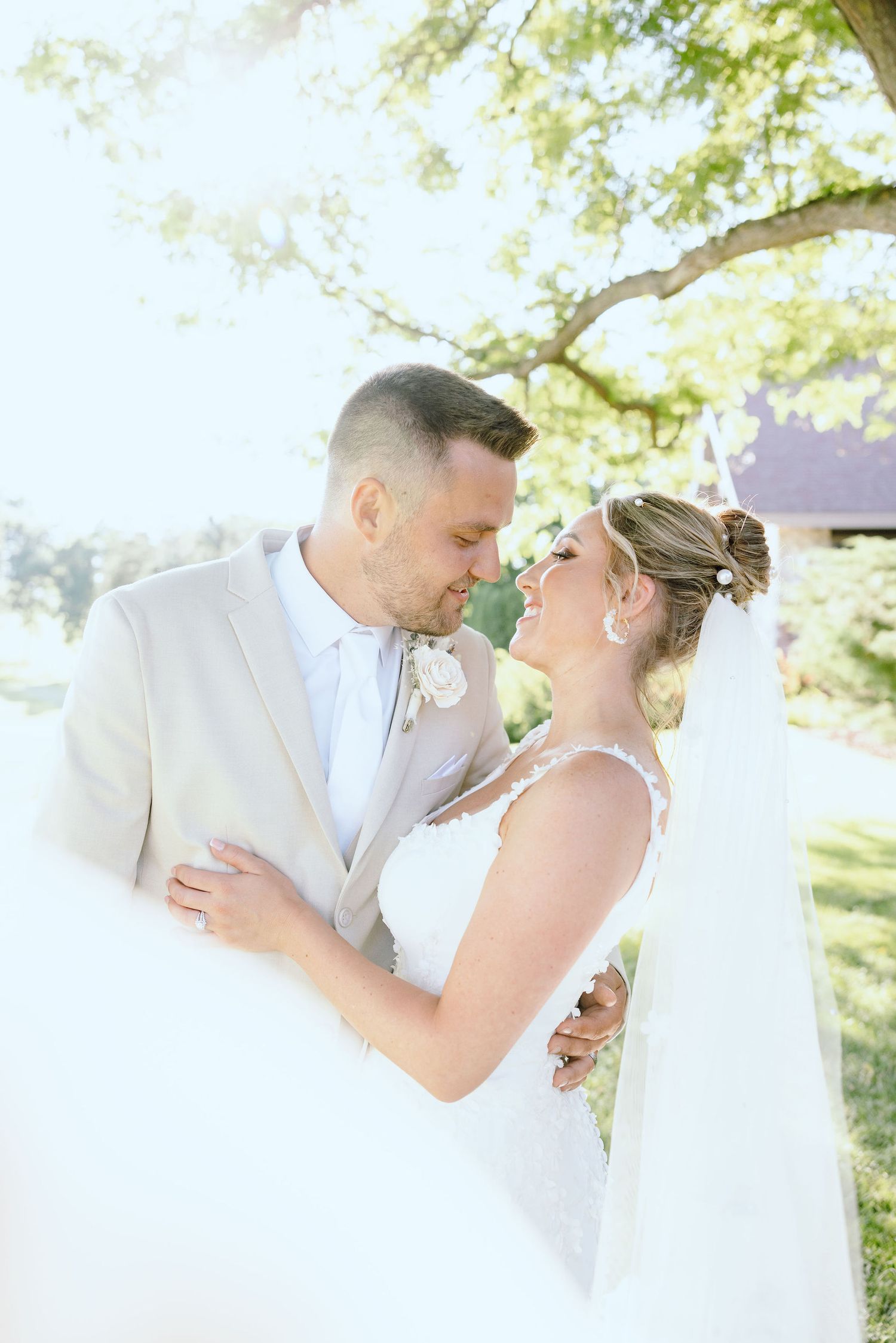 Married couple embracing under veil at Lapeer Country Club wedding in Michigan