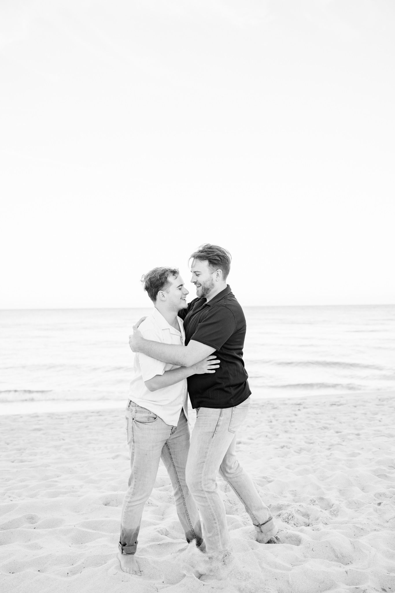 LGBTQ+ couple hugging and laughing on North Miami Beach in Florida