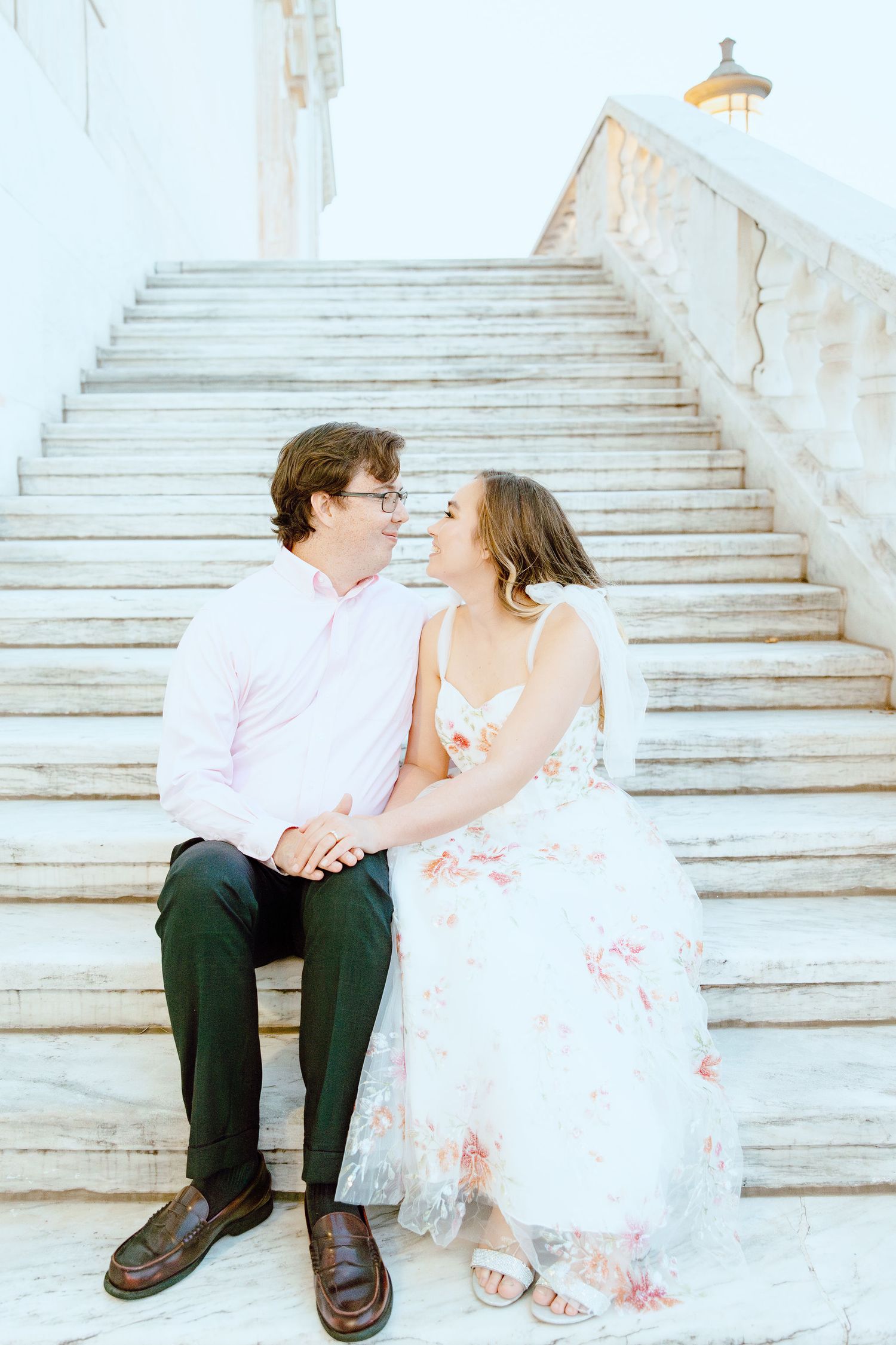 Engaged couple sitting on stairs at Detroit Institute of Arts in Detroit, MI