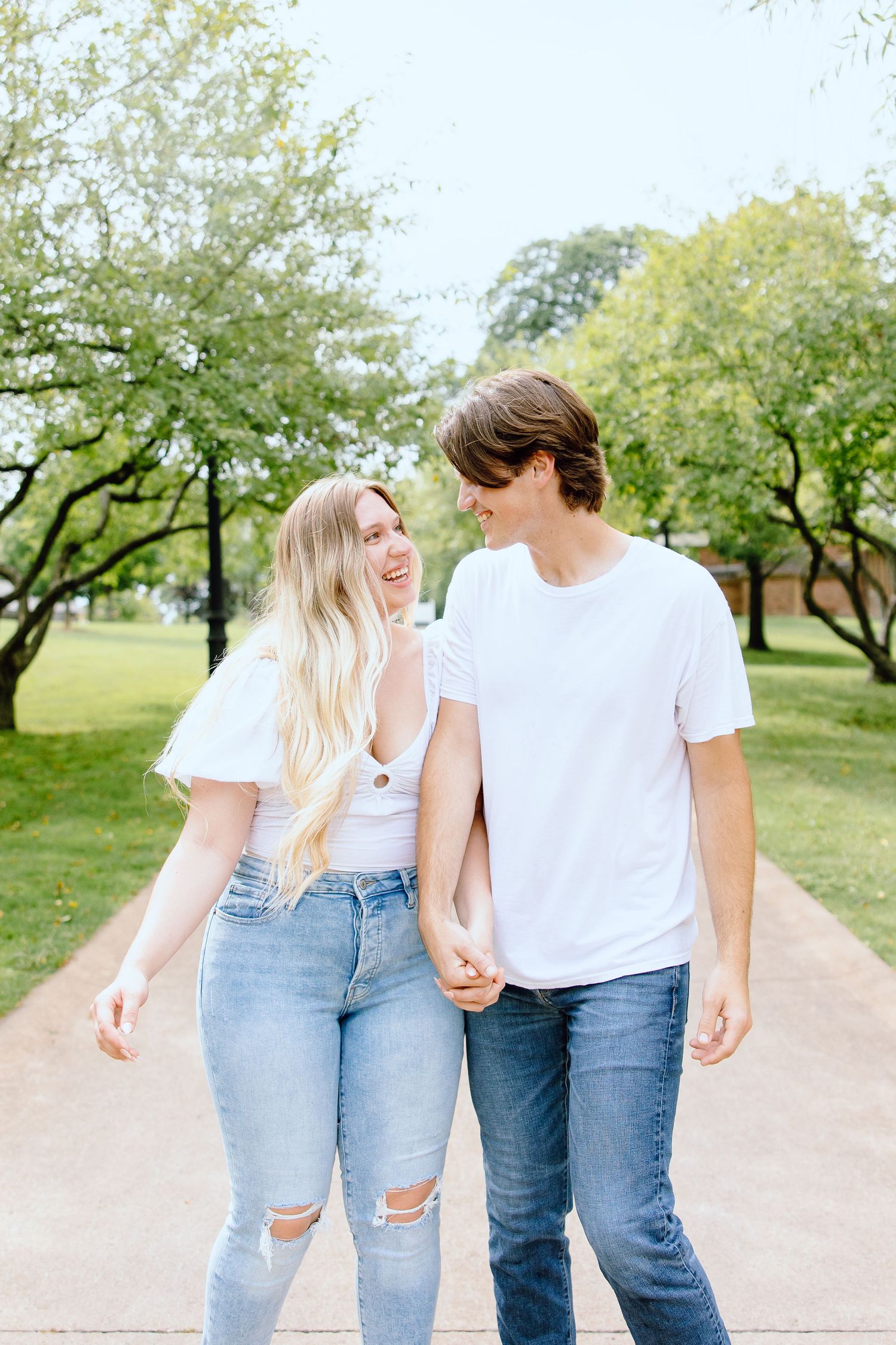 Engaged couple walking and holding hands at Greenfield Village in Dearborn, MI