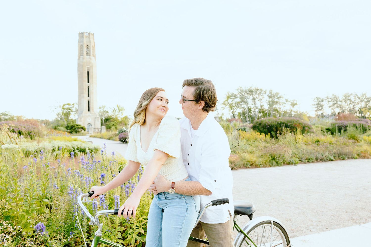 Engaged couple embracing on tandem bike at Belle Isle summer engagement session in Detroit, MI