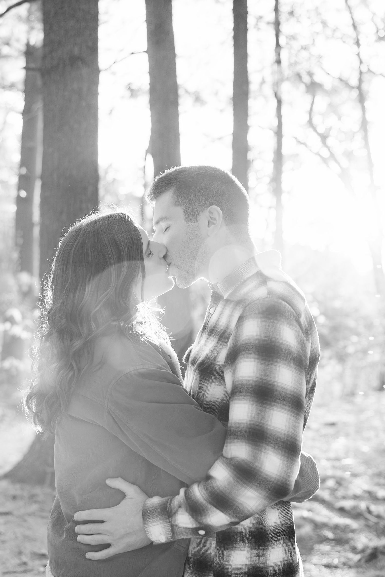 Engaged couple embracing in forest at Nichols Arboretum fall engagement session in Ann Arbor, MI