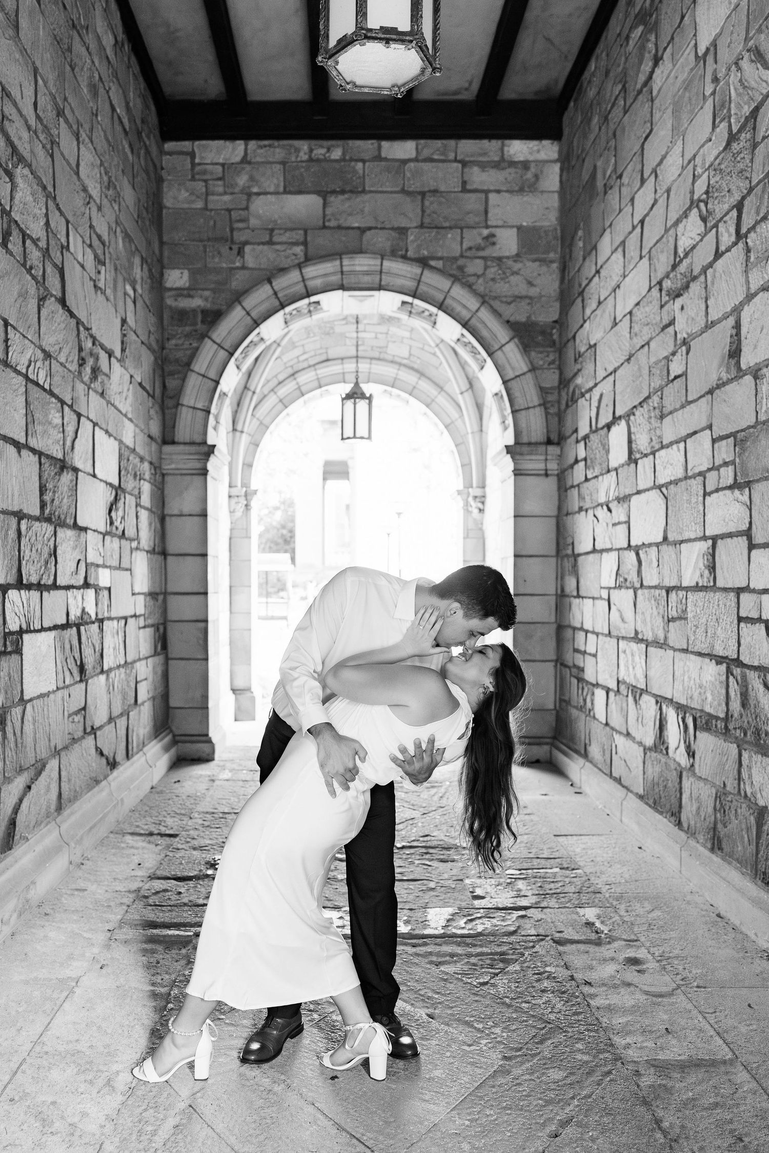 Engaged couple dipping and kissing at the UM Law Quad engagement session in Ann Arbor, MI