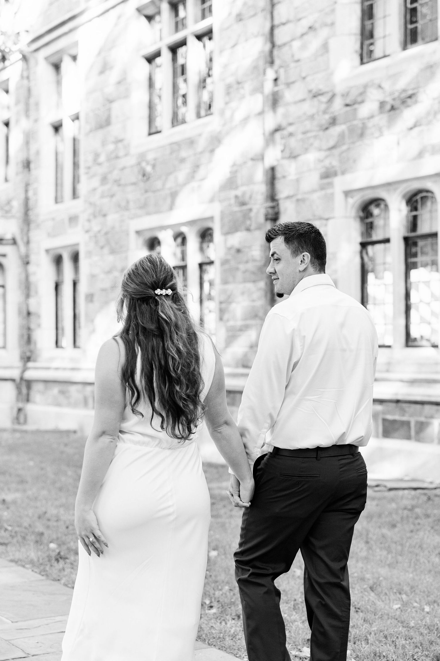 Engaged couple walking and holding hands at the UofM Law Quad engagement session in Ann Arbor, MI
