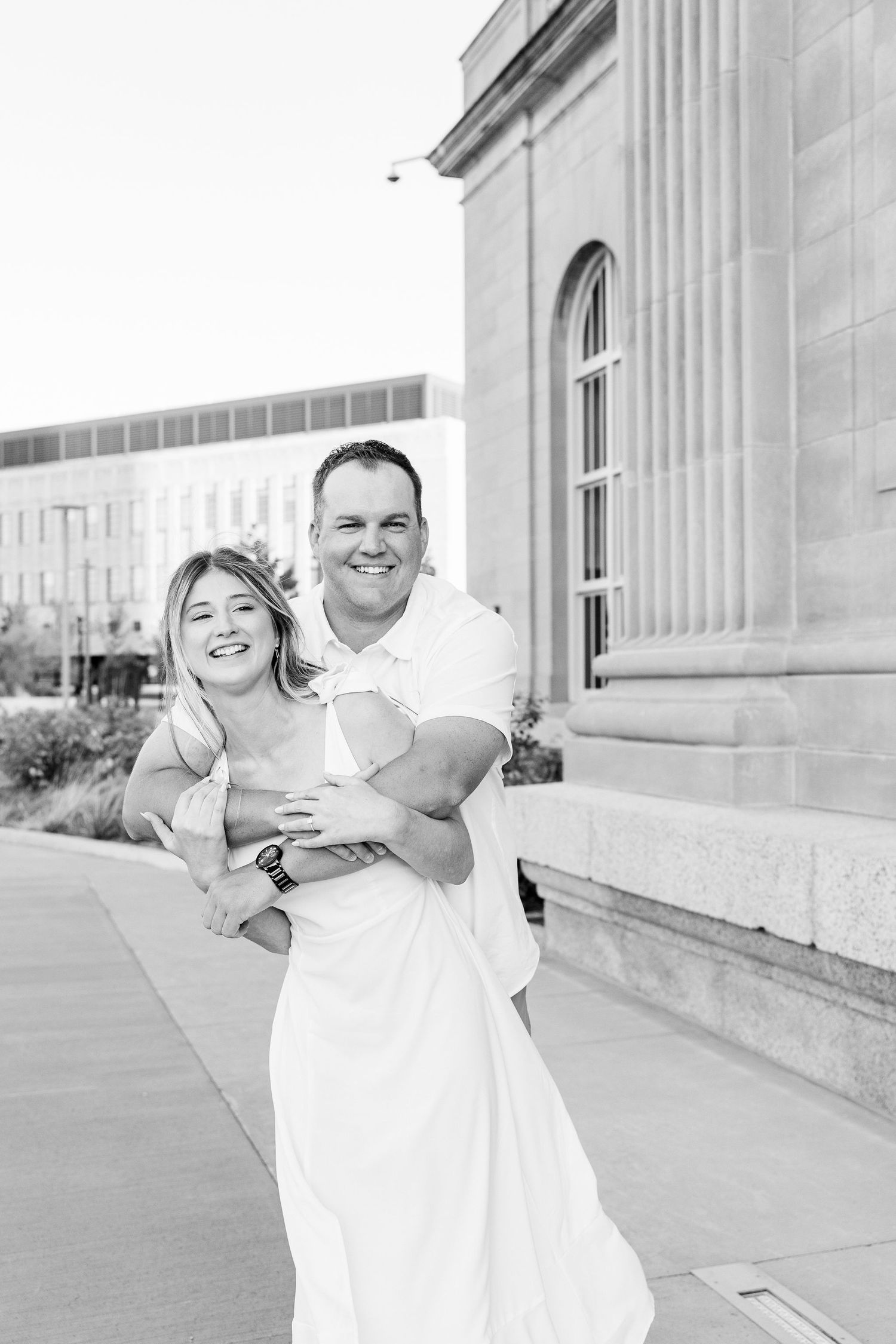 Engaged couple embracing at Michigan Central Station summer engagement session in Detroit, MI
