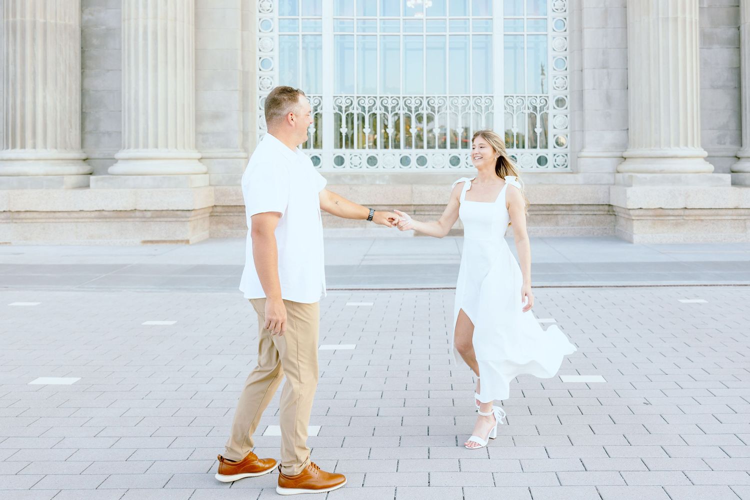 Engaged couple twirling at Michigan Central Station summer engagement session in Detroit, MI