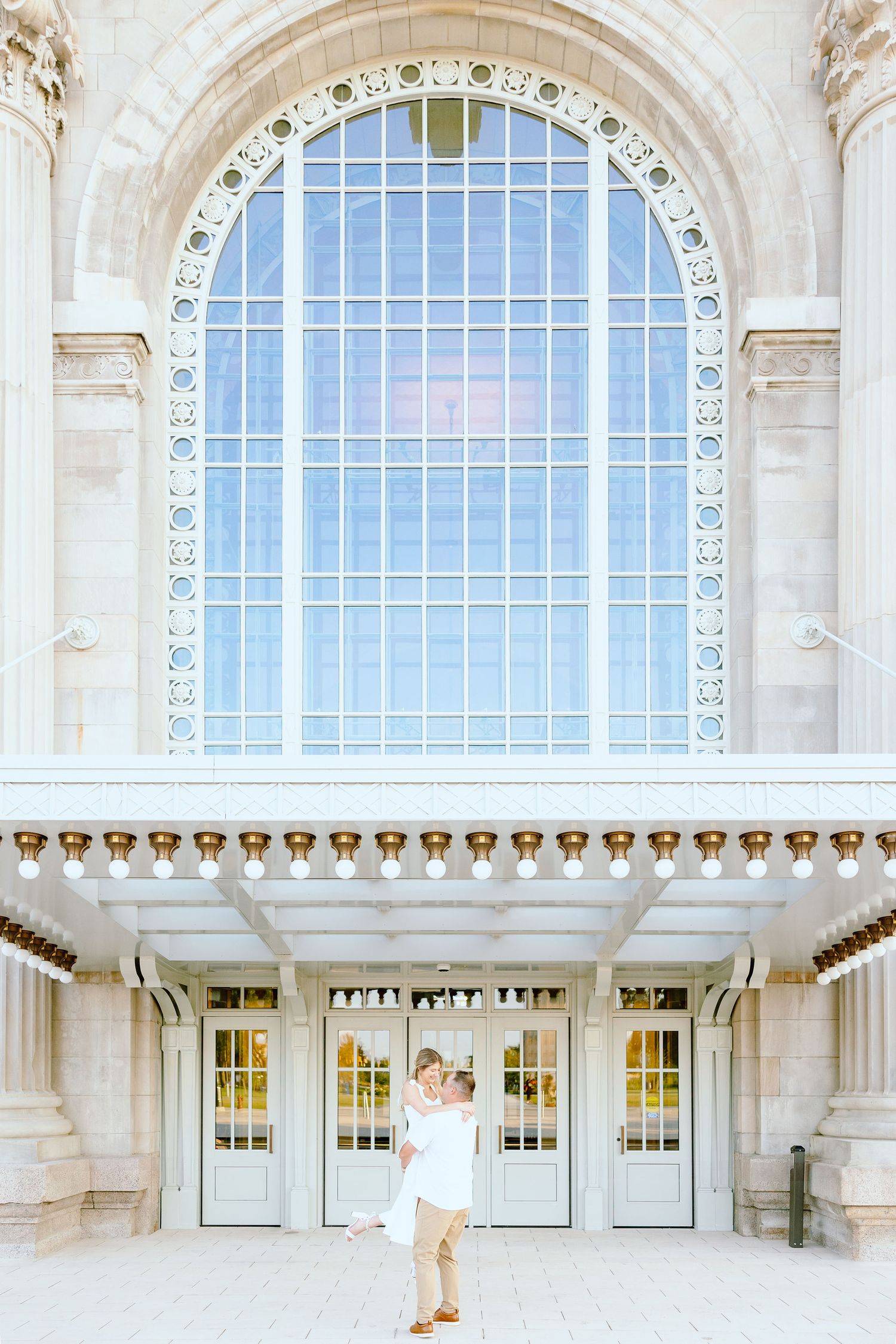 Man lifting woman at Michigan Central Station summer engagement session in Detroit, MI