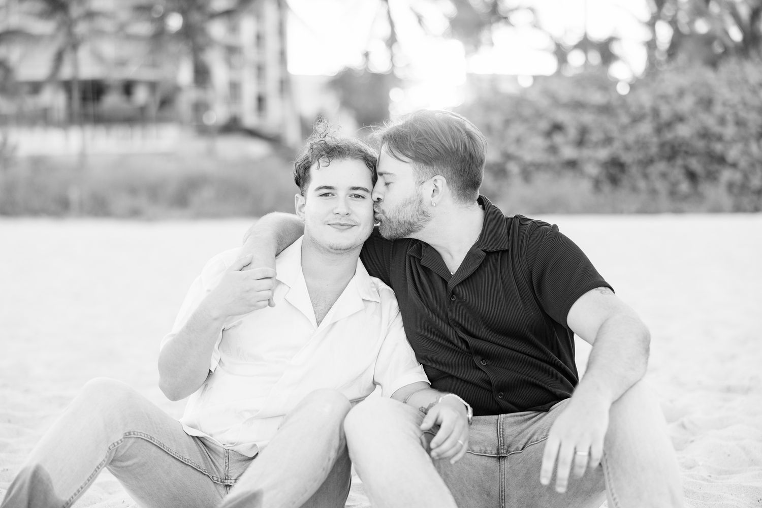 LGBTQ+ standing sitting and kissing cheek on North Miami Beach in Florida