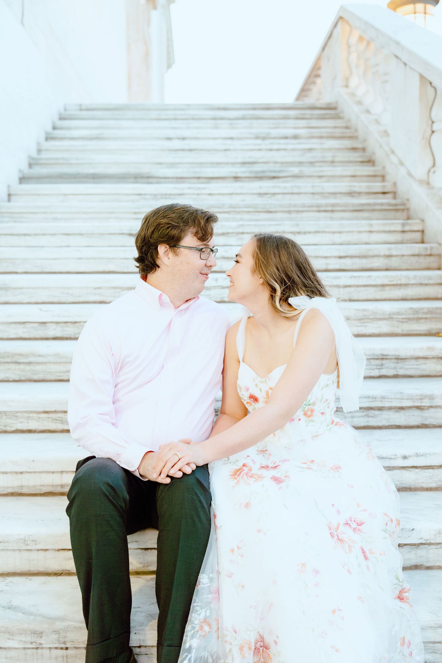 Engaged couple sitting on stairs at Detroit Institute of Arts in Detroit, MI
