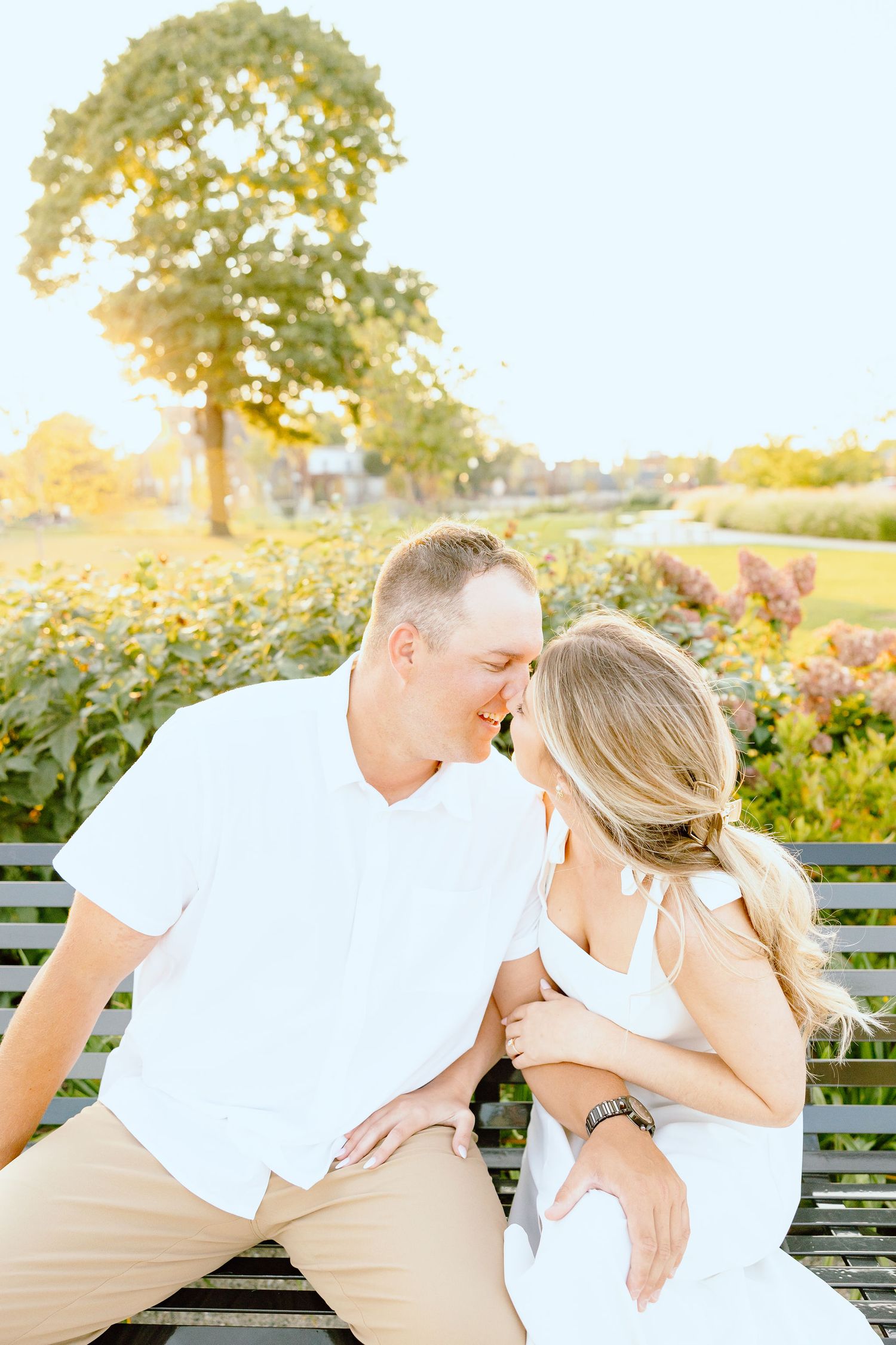 Engaged couple kissing on bench at Michigan Central Station in Detroit, MI