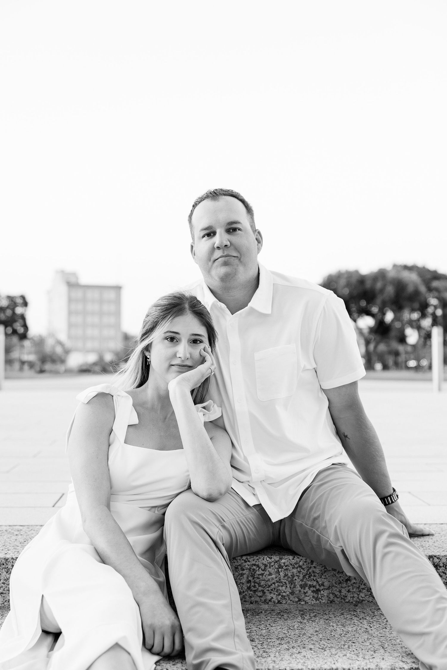 Engaged couple sitting on bench at Michigan Central Station in Detroit, MI
