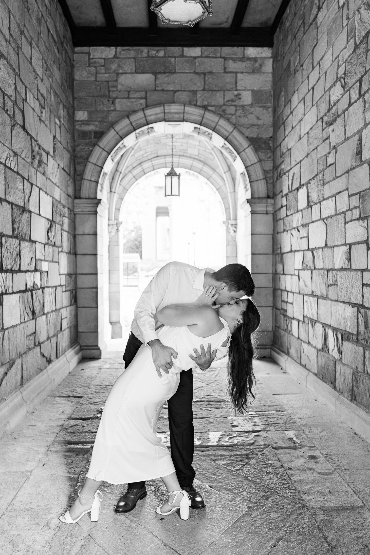 Engaged couple dipping and kissing at the UM Law Quad engagement session in Ann Arbor, MI