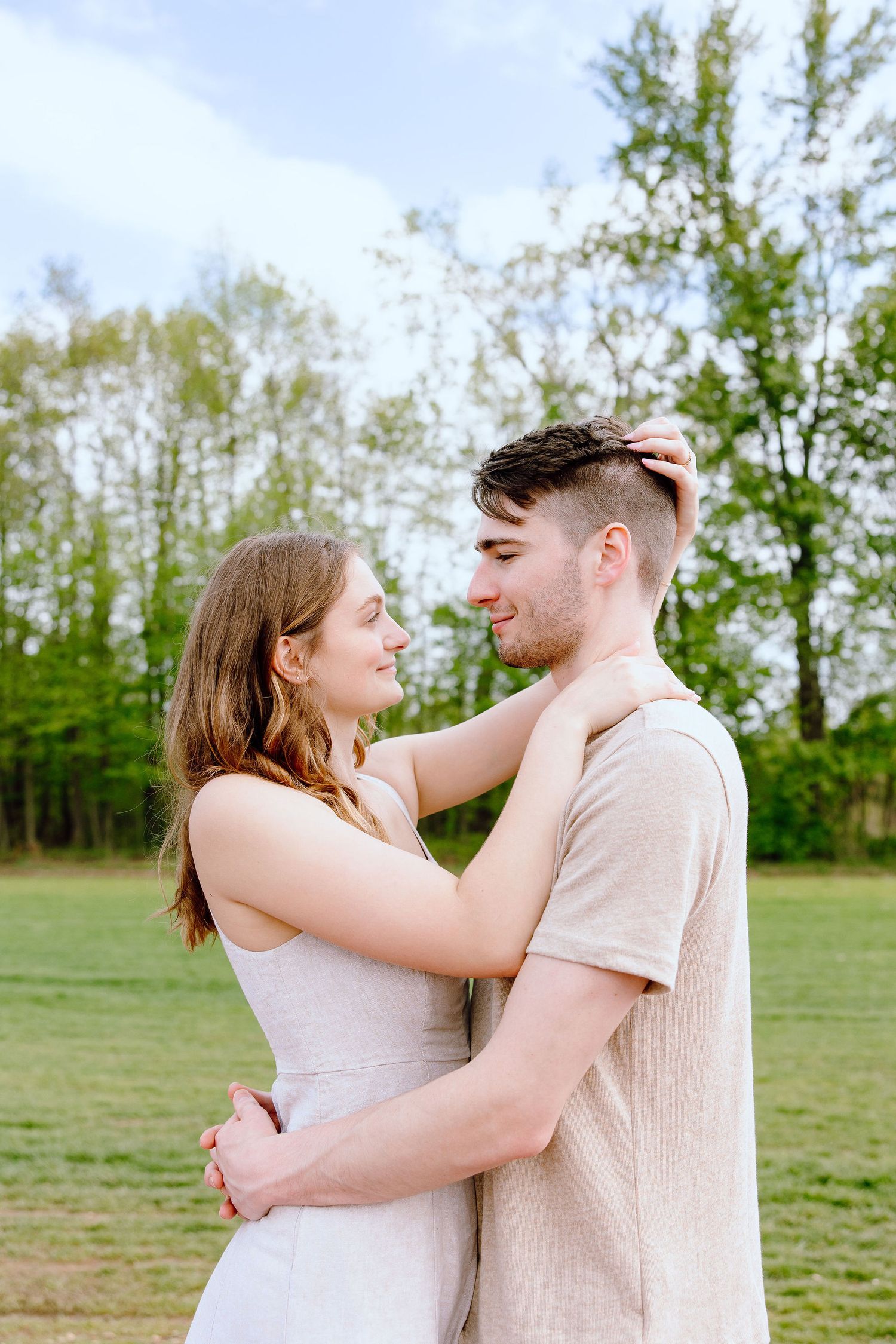 Engaged couple embracing at DeBuck's tulip field spring engagement session in Belleville, MI