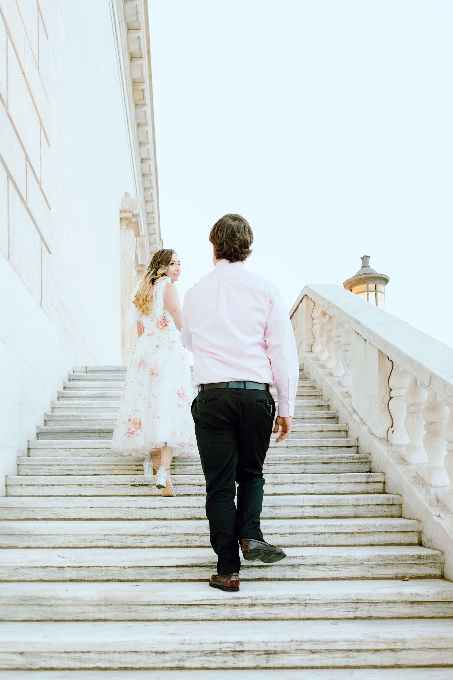 Engaged couple walking up stairs at Detroit Institute of Arts in Detroit, MI