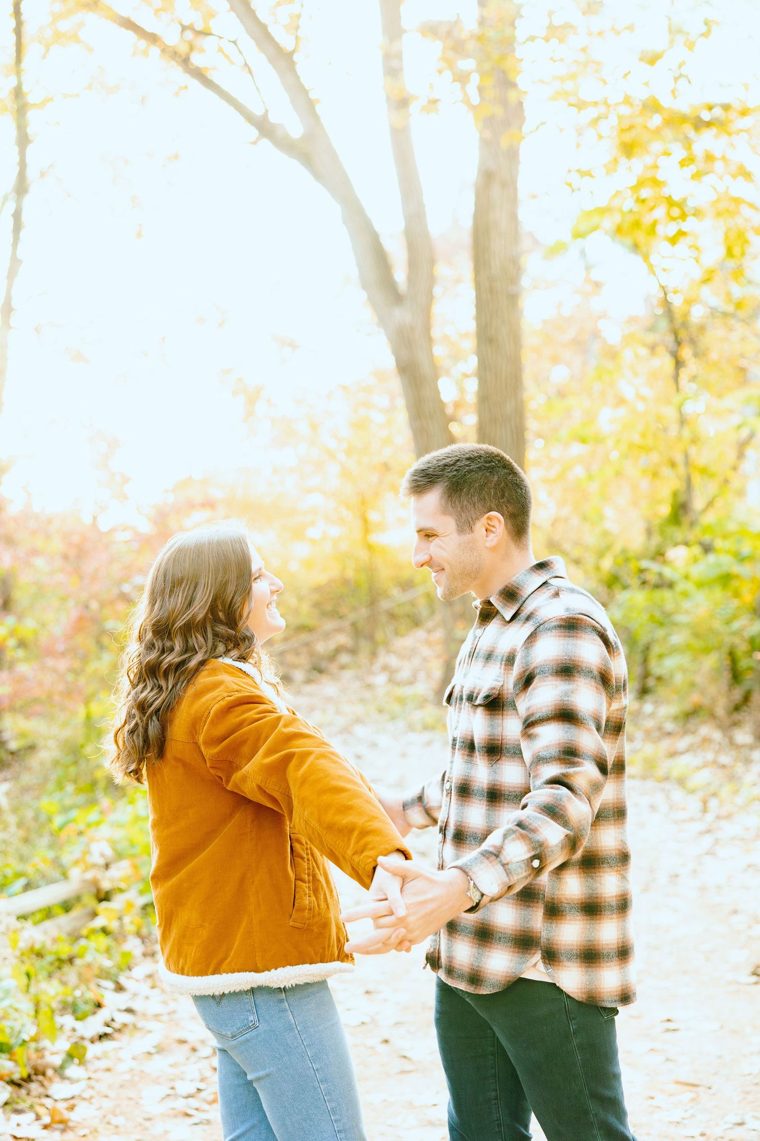 Engaged couple embracing in forest at Nichols Arboretum fall engagement session in Ann Arbor, MI