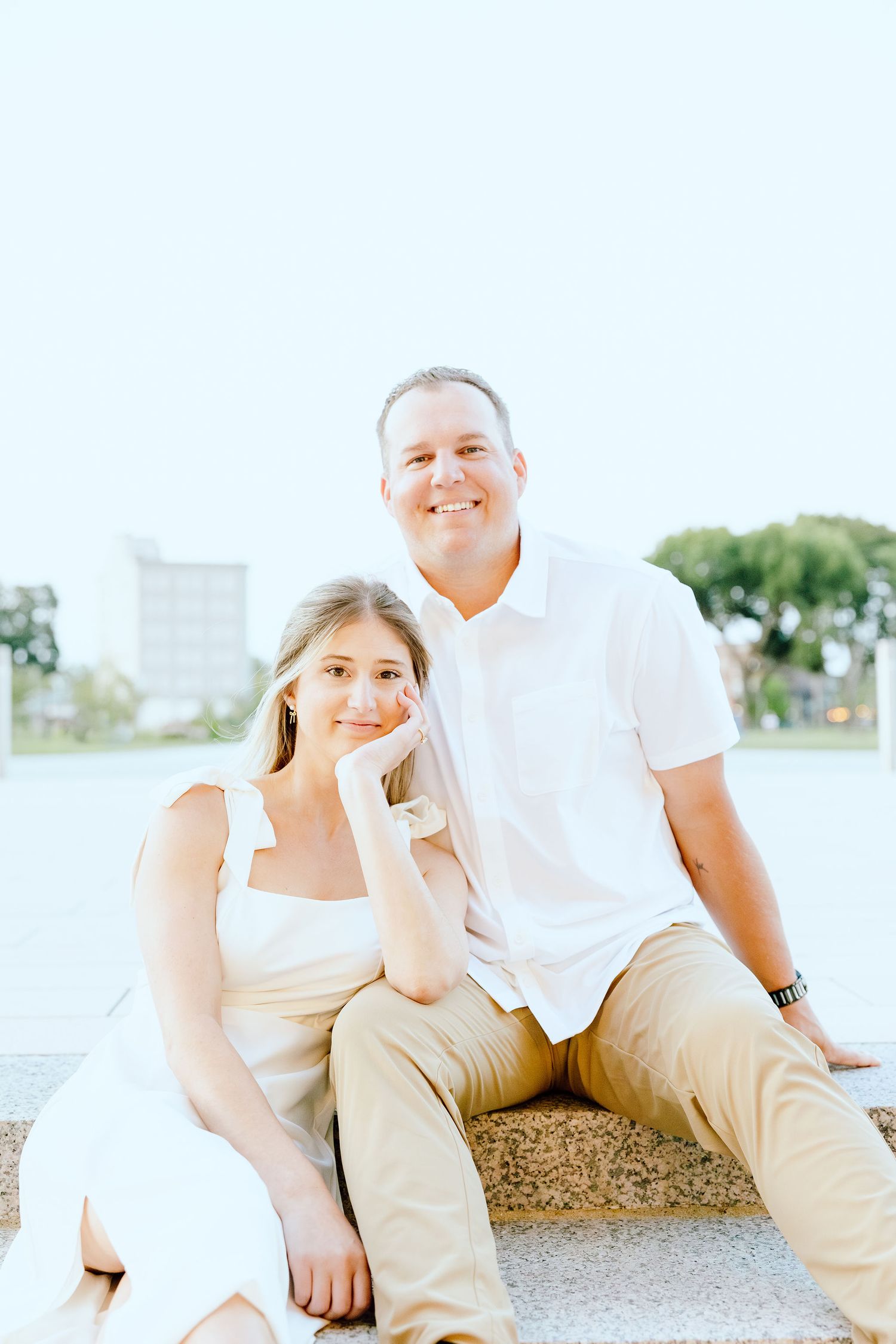 Engaged couple sitting on bench at Michigan Central Station in Detroit, MI