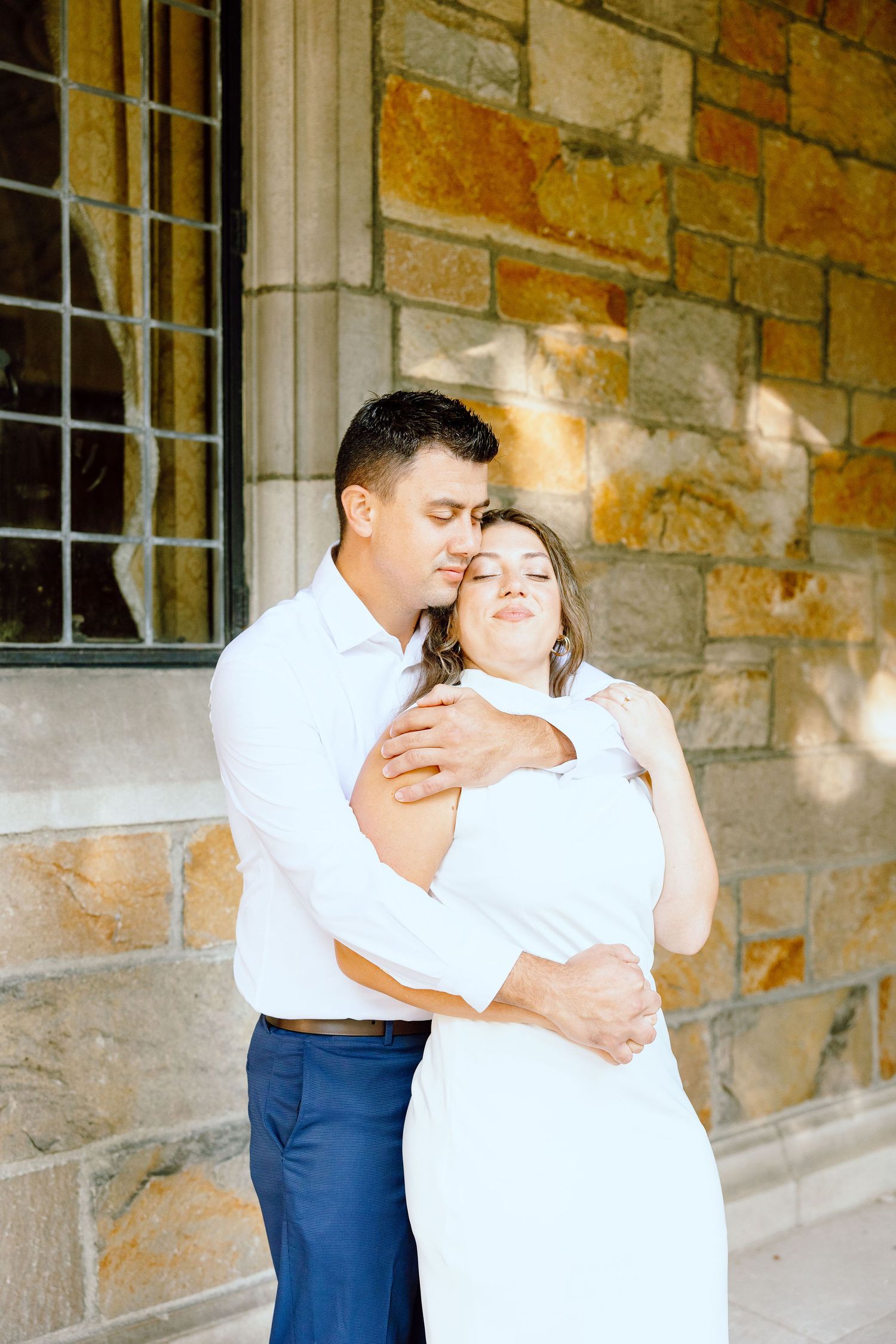 Engaged couple embracing at the University of Michigan Law Quad engagement session in Ann Arbor, MI