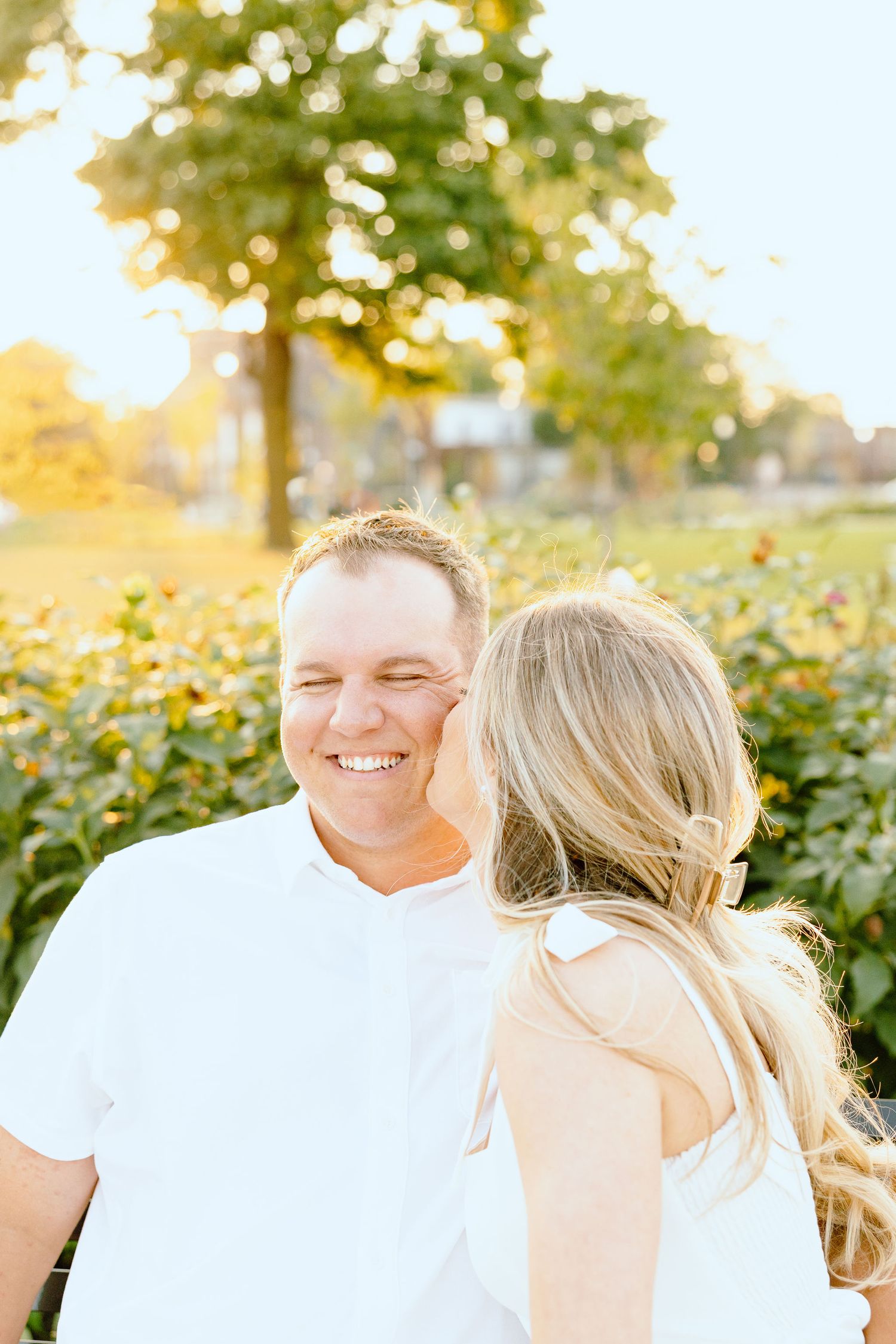 Engaged couple embracing on bench at Michigan Central Station in Detroit, MI