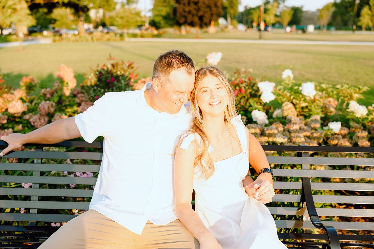 Engaged couple embracing on bench at Michigan Central Station in Detroit, MI