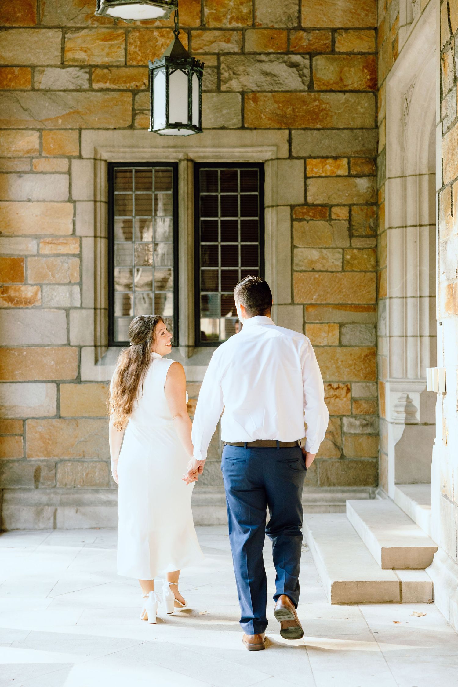 Engaged couple walking and holding hands at the UofM Law Quad engagement session in Ann Arbor, MI