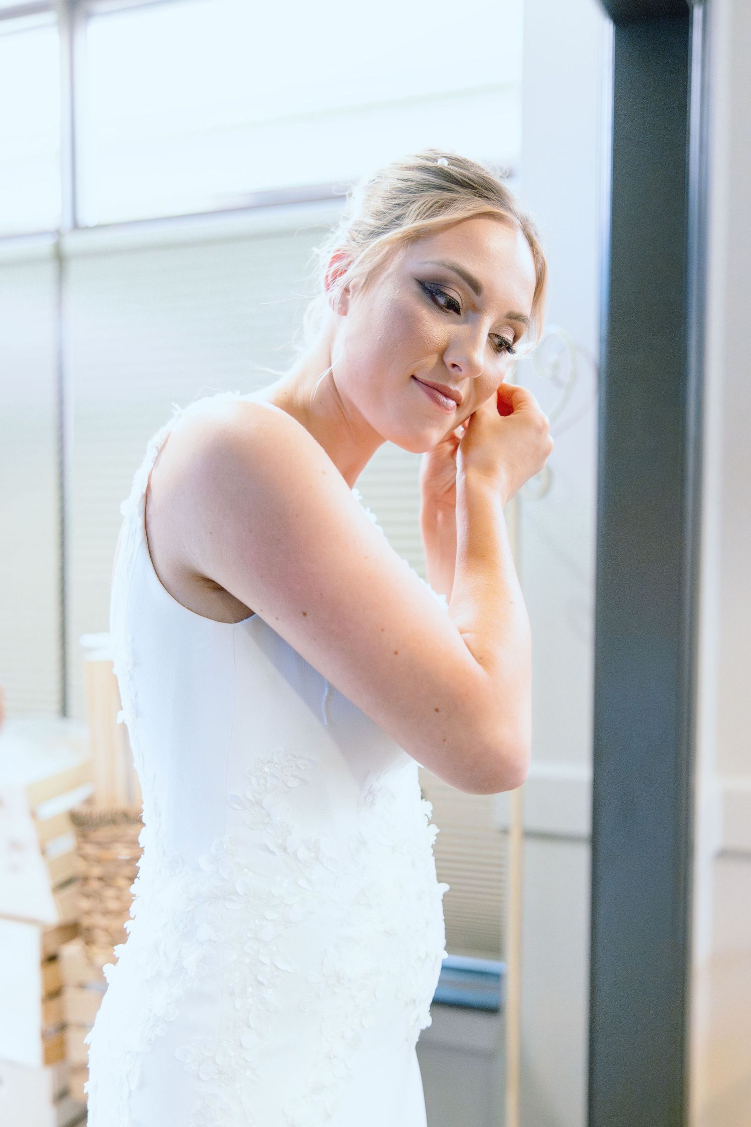 Bride holding earring at Lapeer Country Club wedding in Michigan