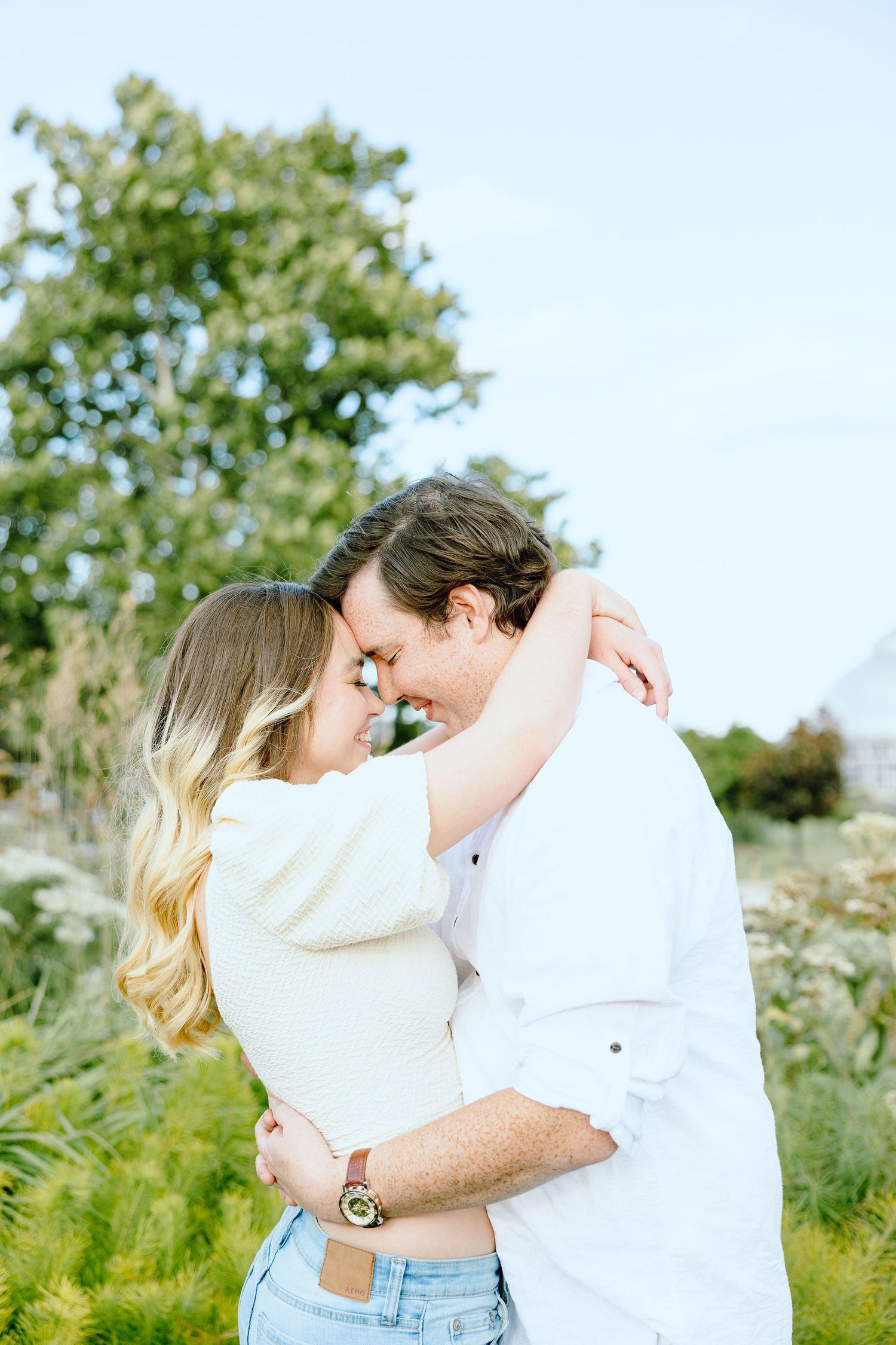 Engaged couple embracing at Belle Isle summer engagement session in Detroit, MI