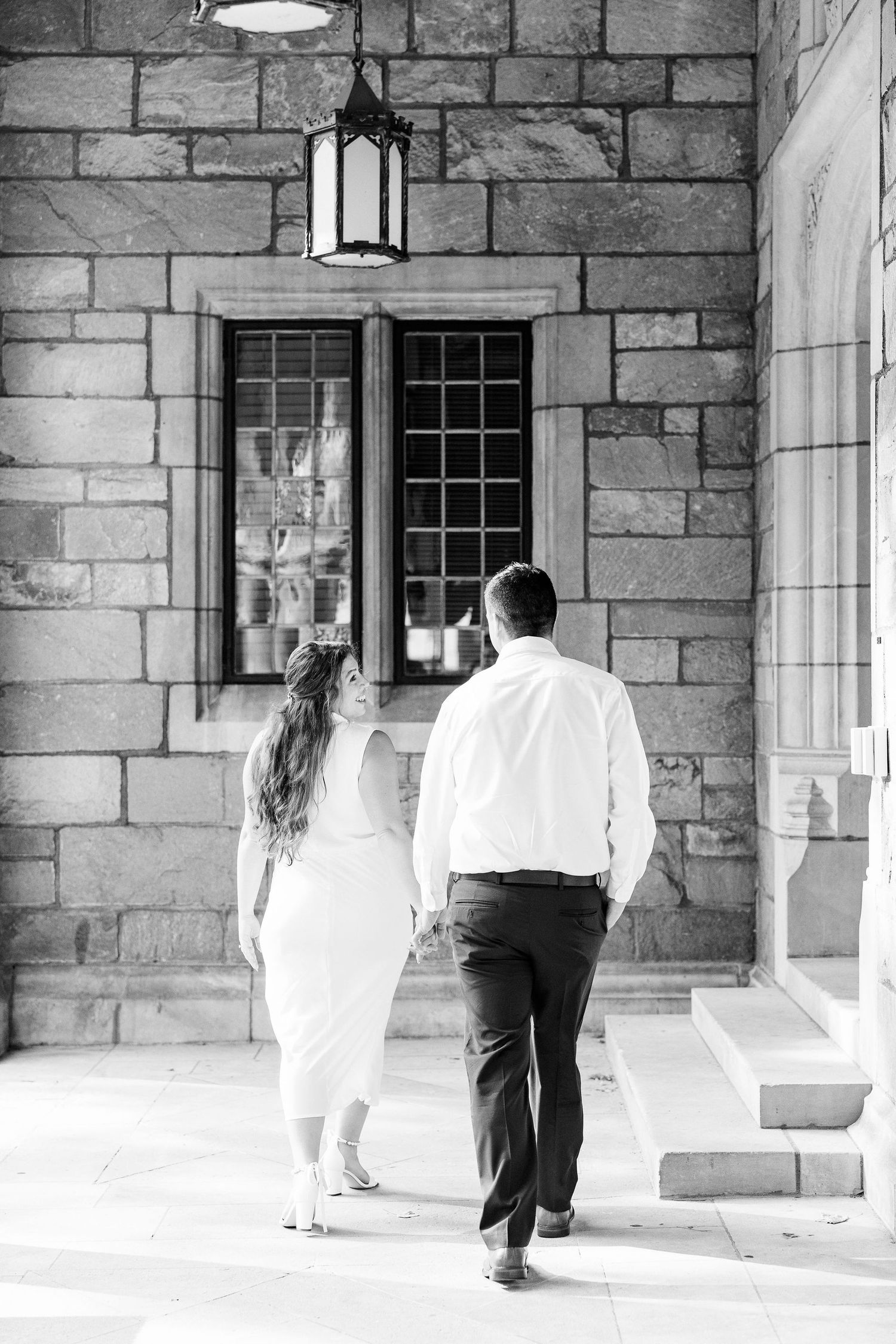 Engaged couple walking and holding hands at the UofM Law Quad engagement session in Ann Arbor, MI