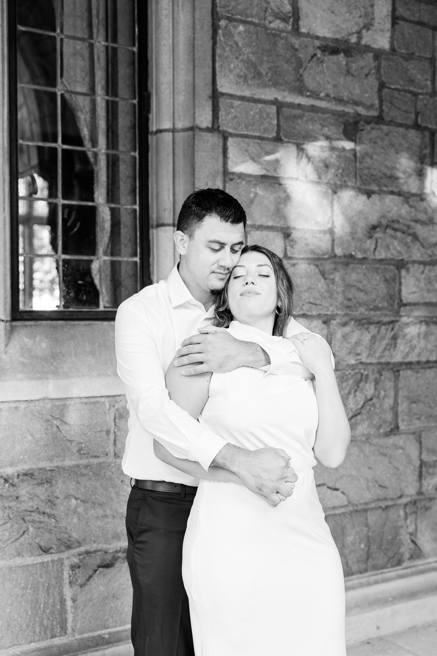 Engaged couple embracing at the University of Michigan Law Quad engagement session in Ann Arbor, MI