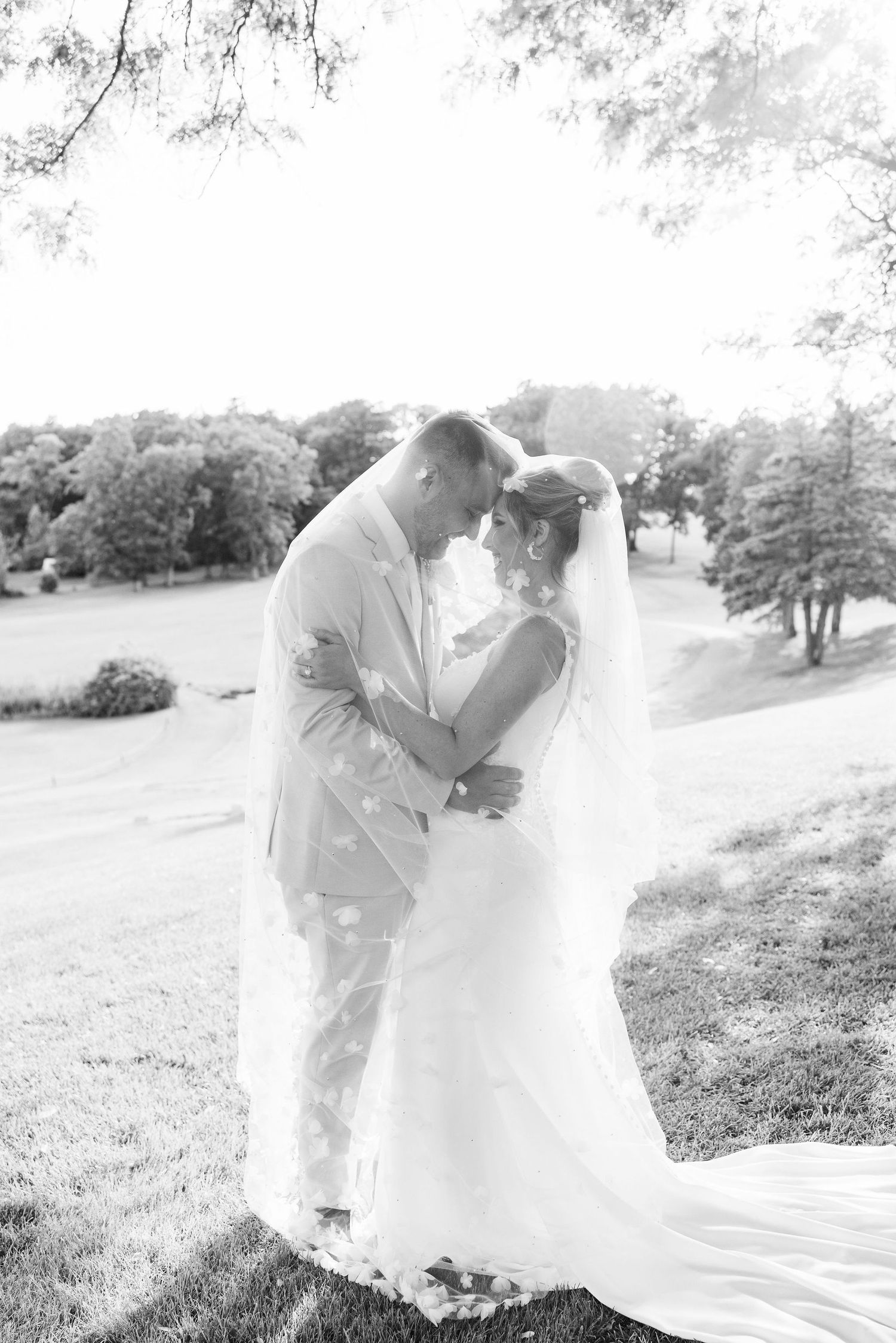 Married couple embracing under veil at Lapeer Country Club wedding in Michigan