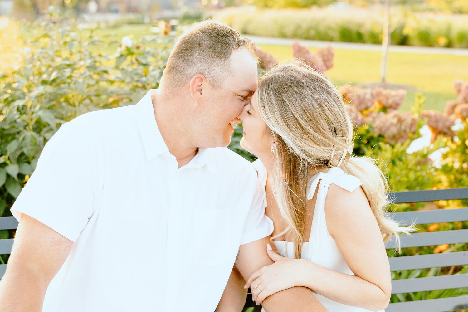 Engaged couple embracing on bench at Michigan Central Station in Detroit, MI