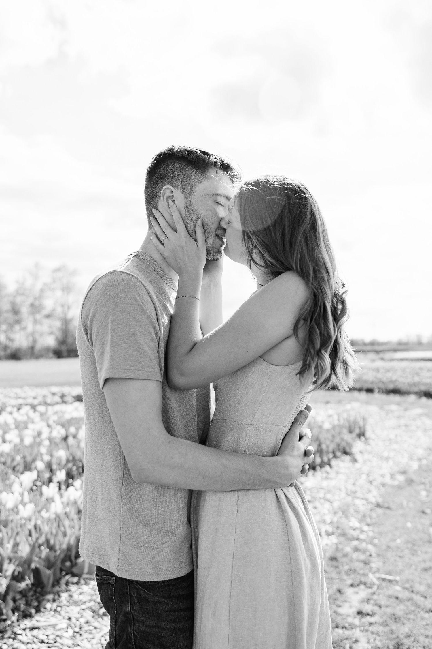 Engaged couple kissing at DeBuck's tulip field spring engagement session in Belleville, MI