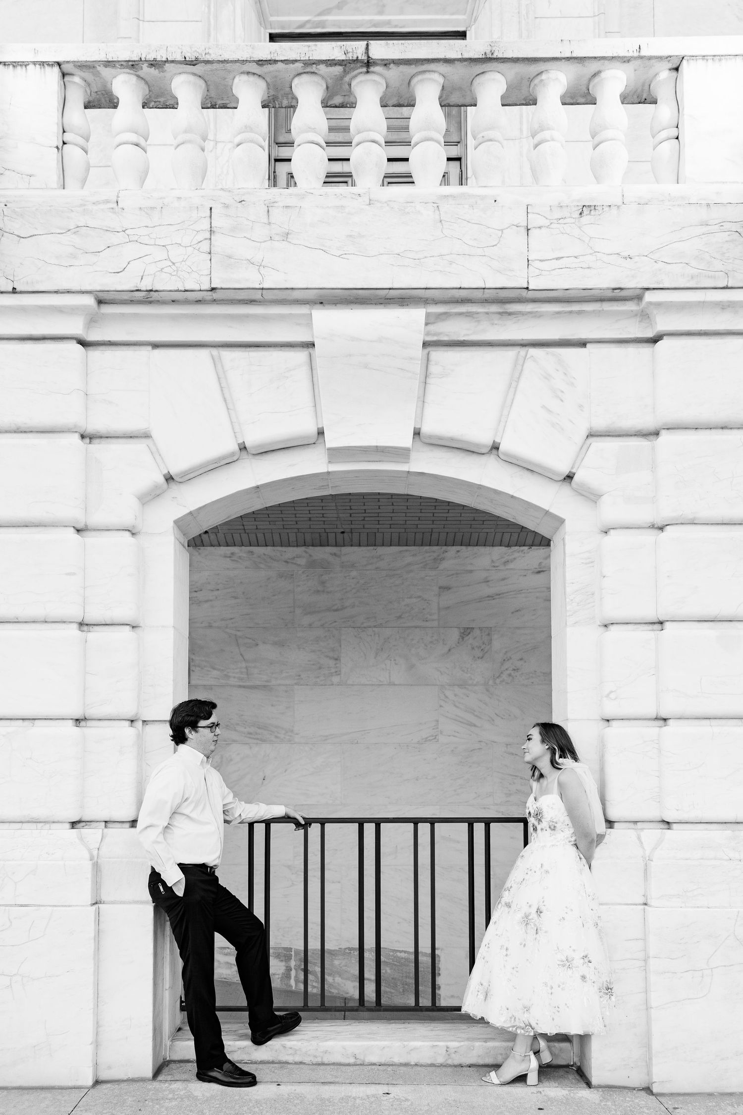 Engaged couple leaning against wall at Belle Isle summer engagement session in Detroit, MI