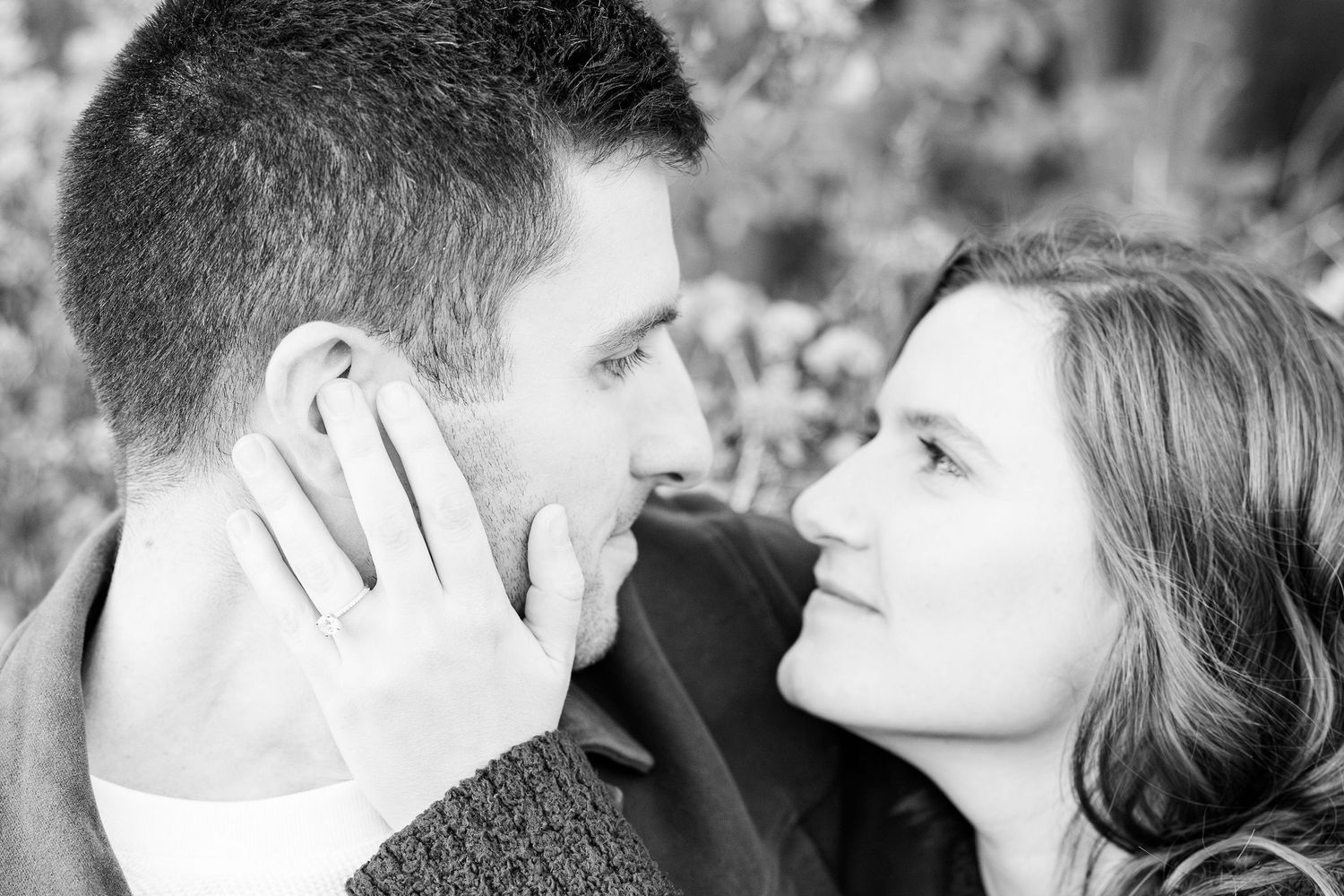Engaged couple embracing on bench at Nichols Arboretum in Ann Arbor, MI