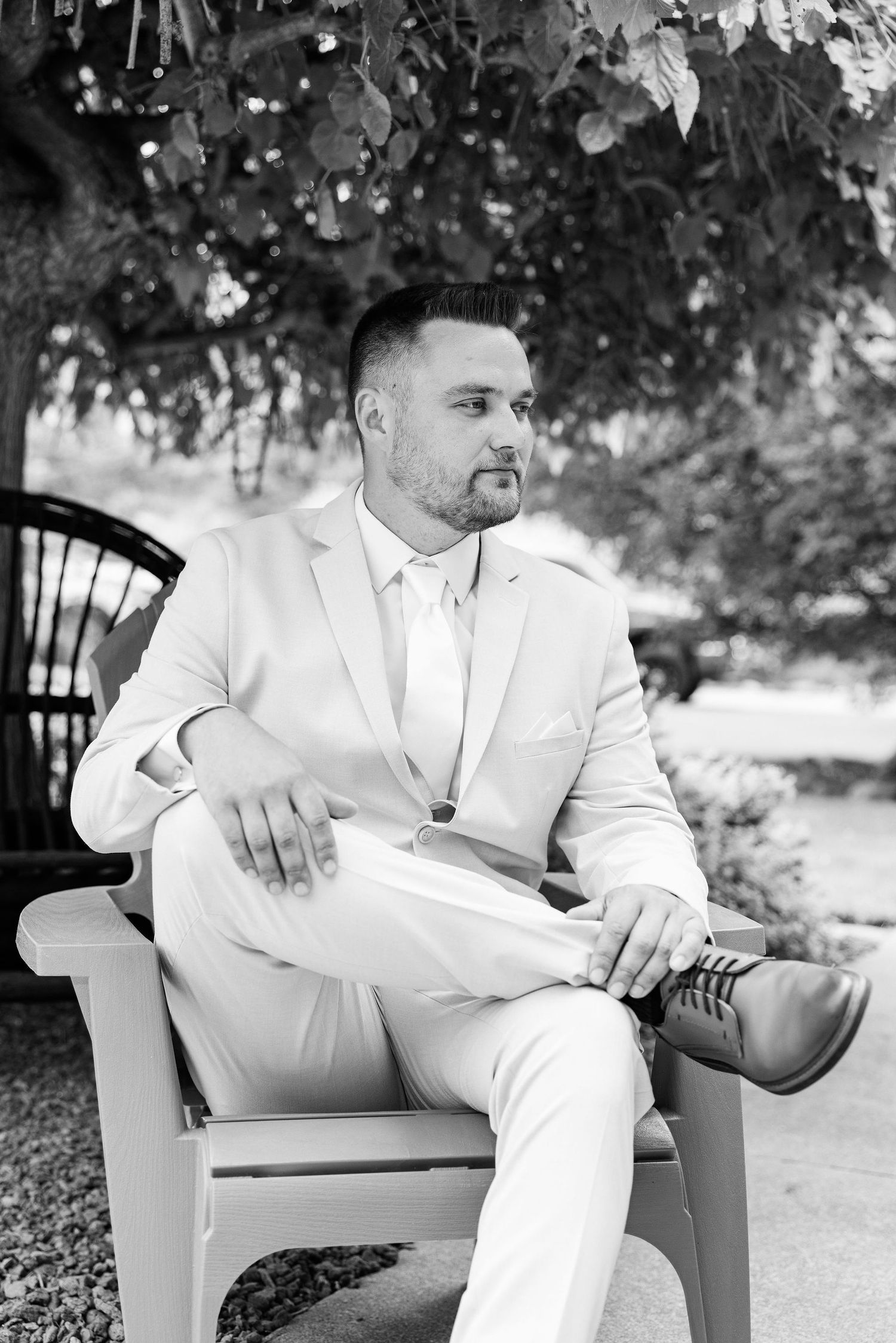 Portraits of groom sitting at Lapeer Country Club wedding in Michigan