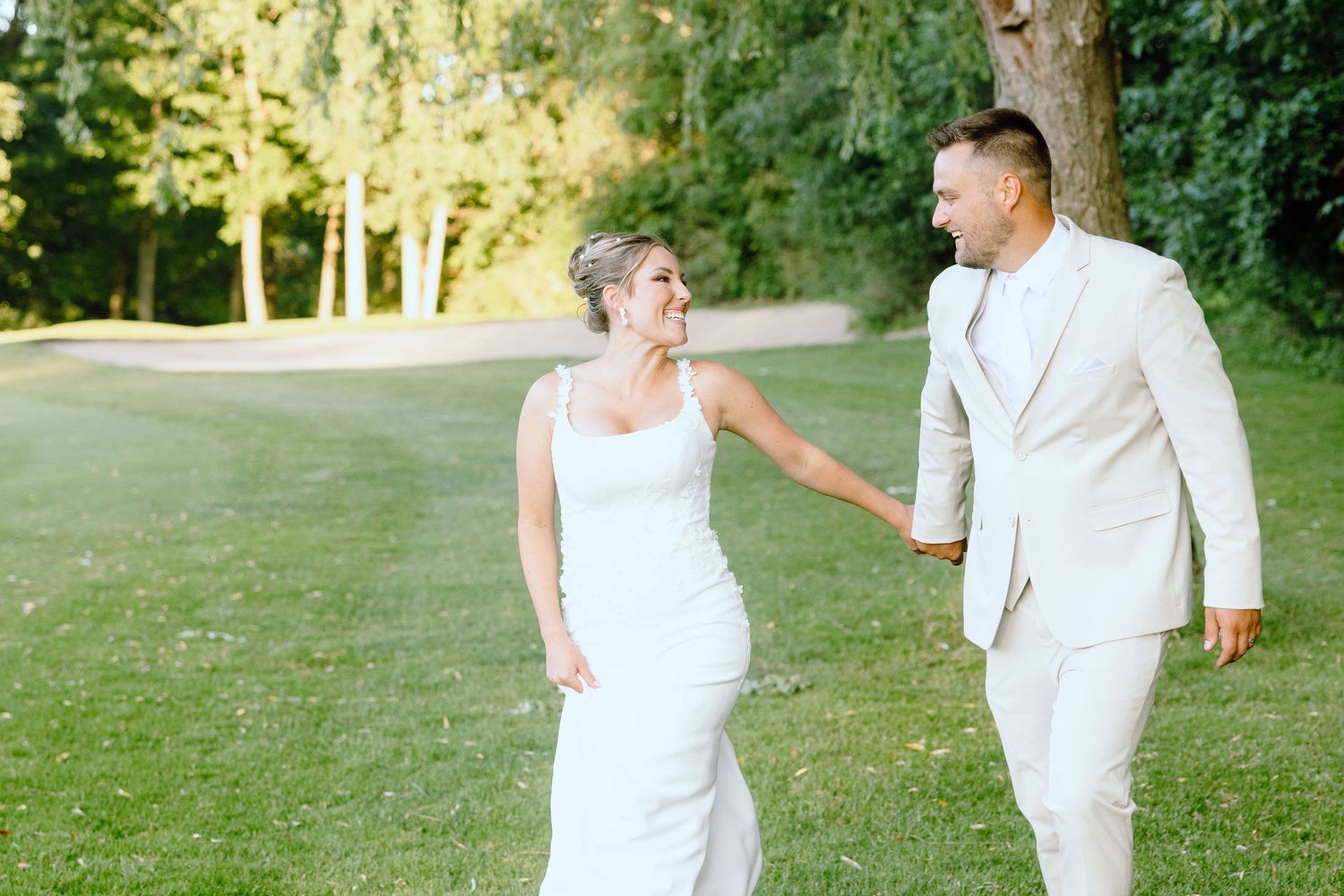 Married couple walking during golden hour at Lapeer Country Club wedding in Michigan