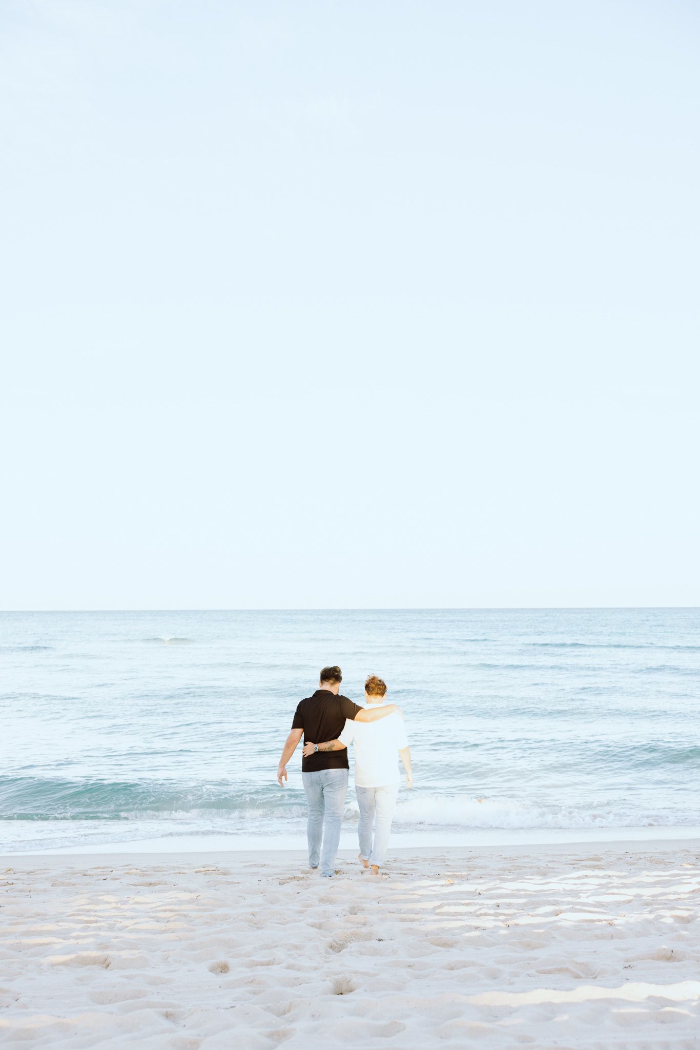 LGBTQ+ couple walking and holding hands on North Miami Beach in Florida