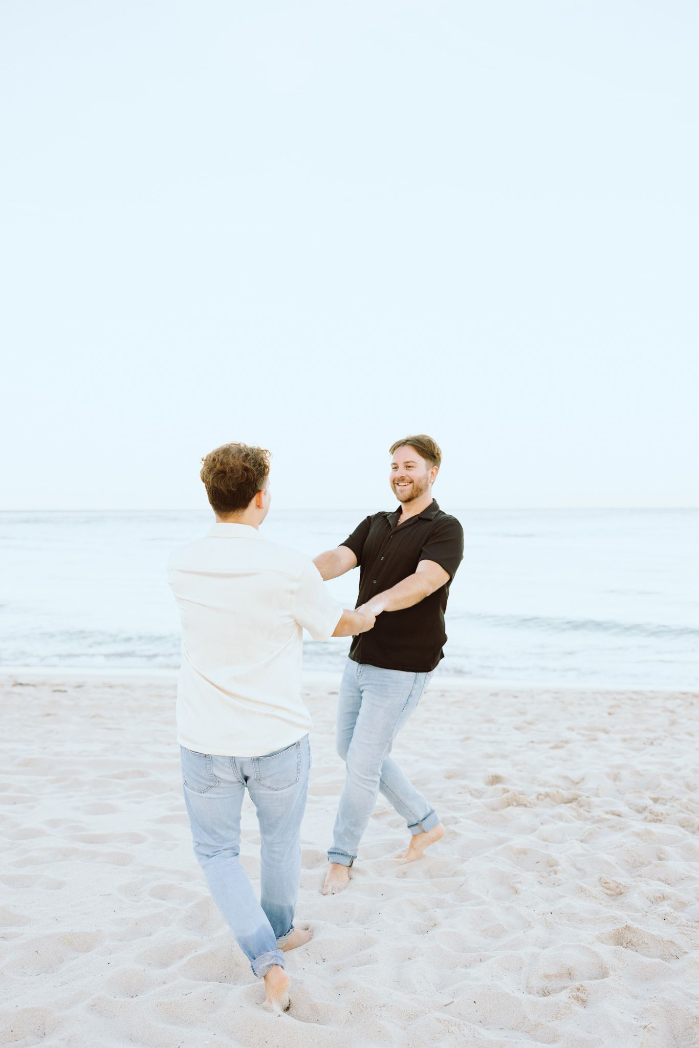 Gay couple holding hands and spinning at North Miami Beach in Florida