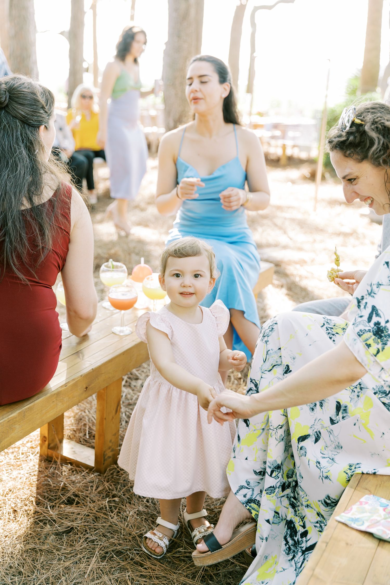 Wedding guests enjoy refreshments and conversation at an outdoor celebration.