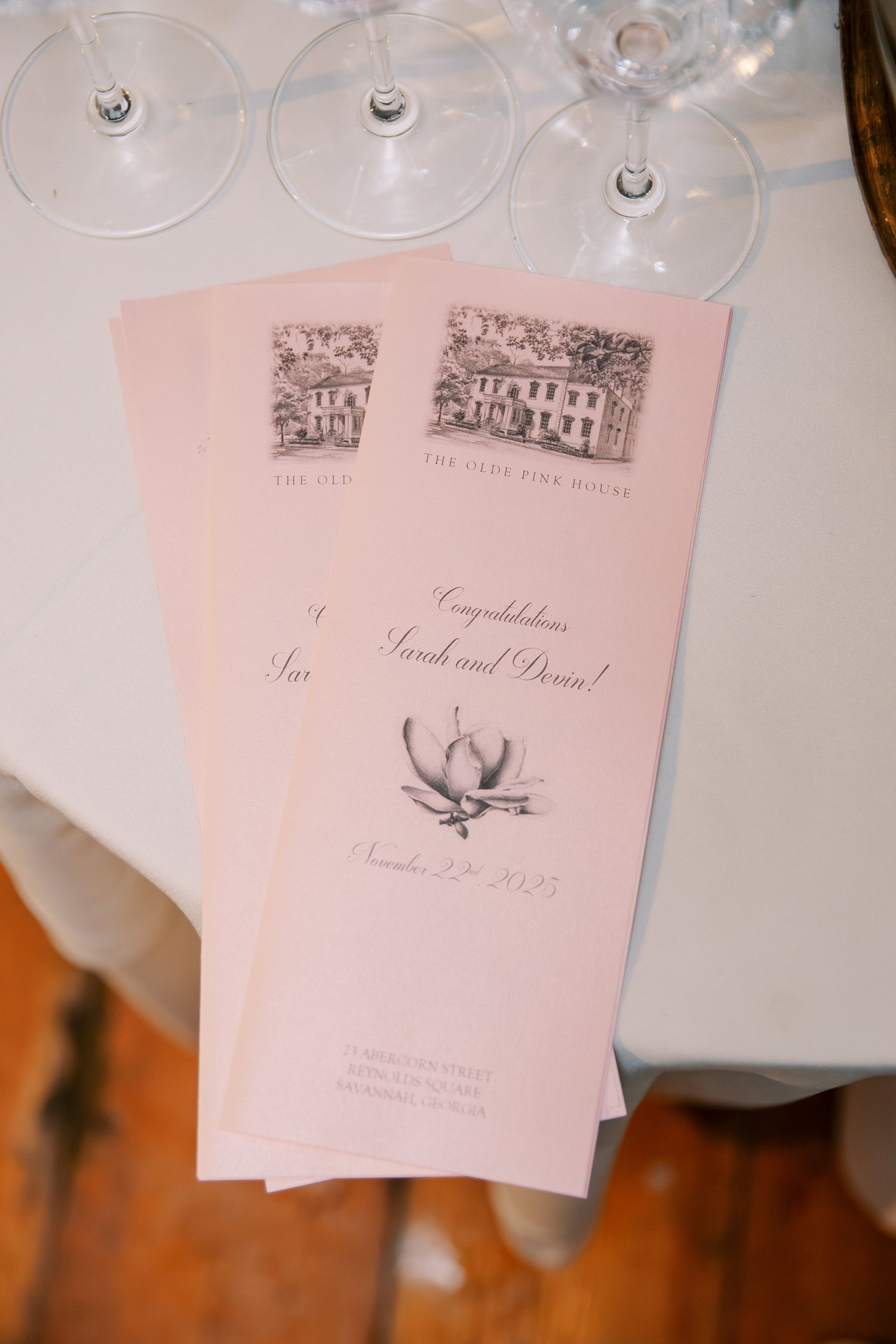 Wedding reception place cards and menus with delicate architectural sketches in soft pink tones.