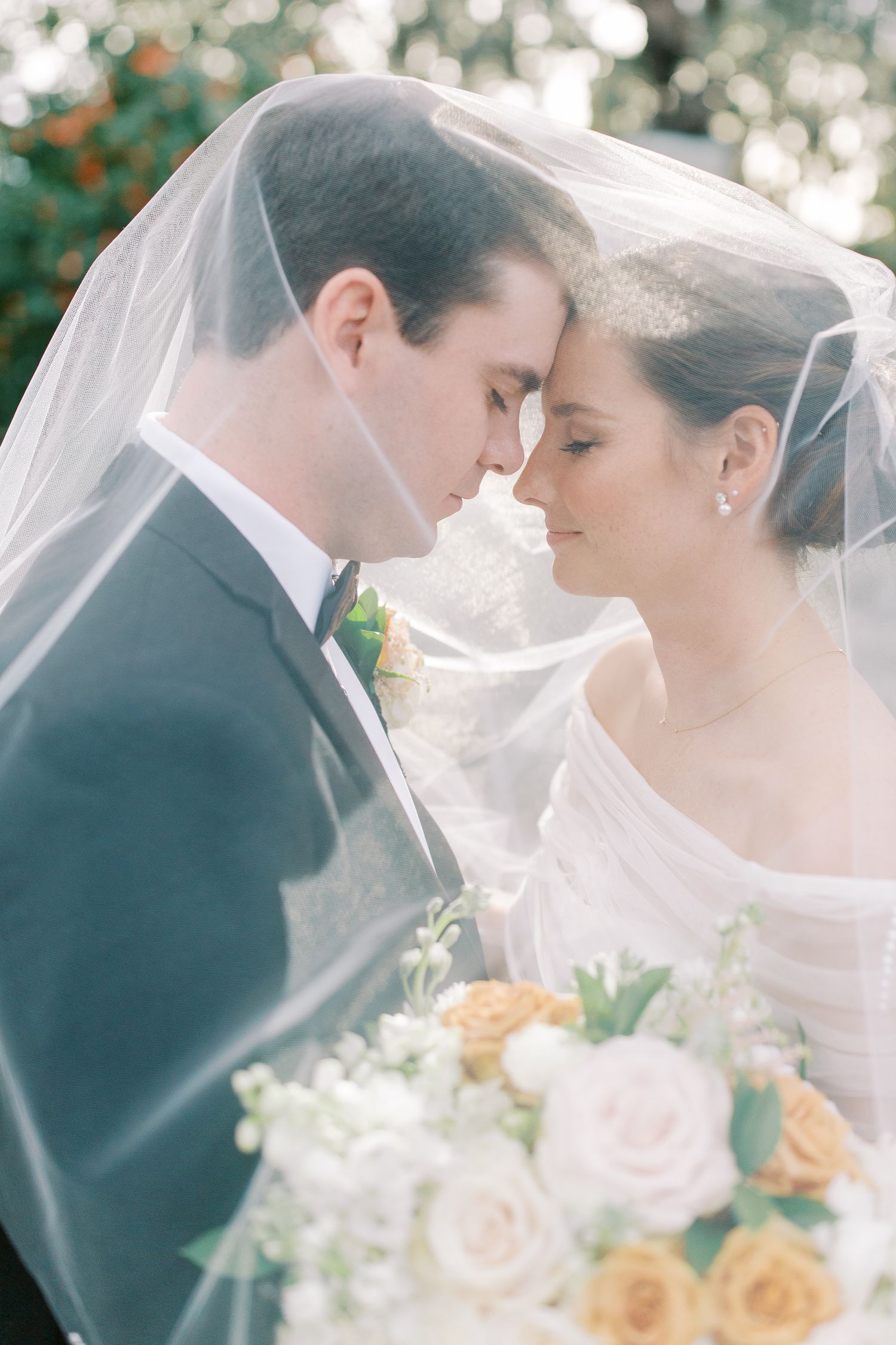 Intimate wedding portrait with soft bokeh and peach roses.