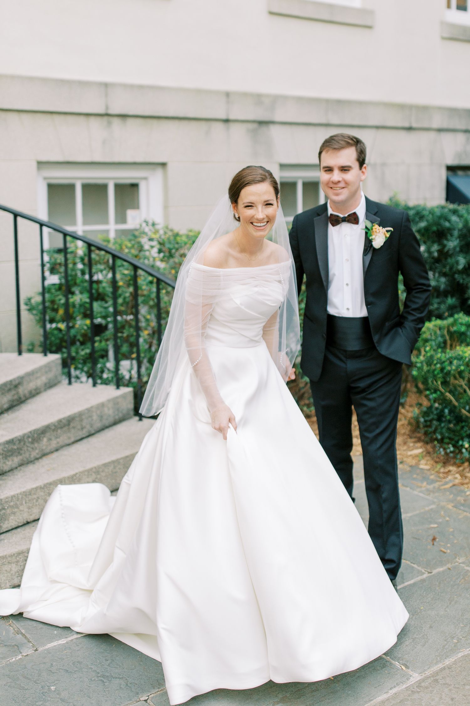 Classic wedding portrait on stone steps with elegant white ball gown.