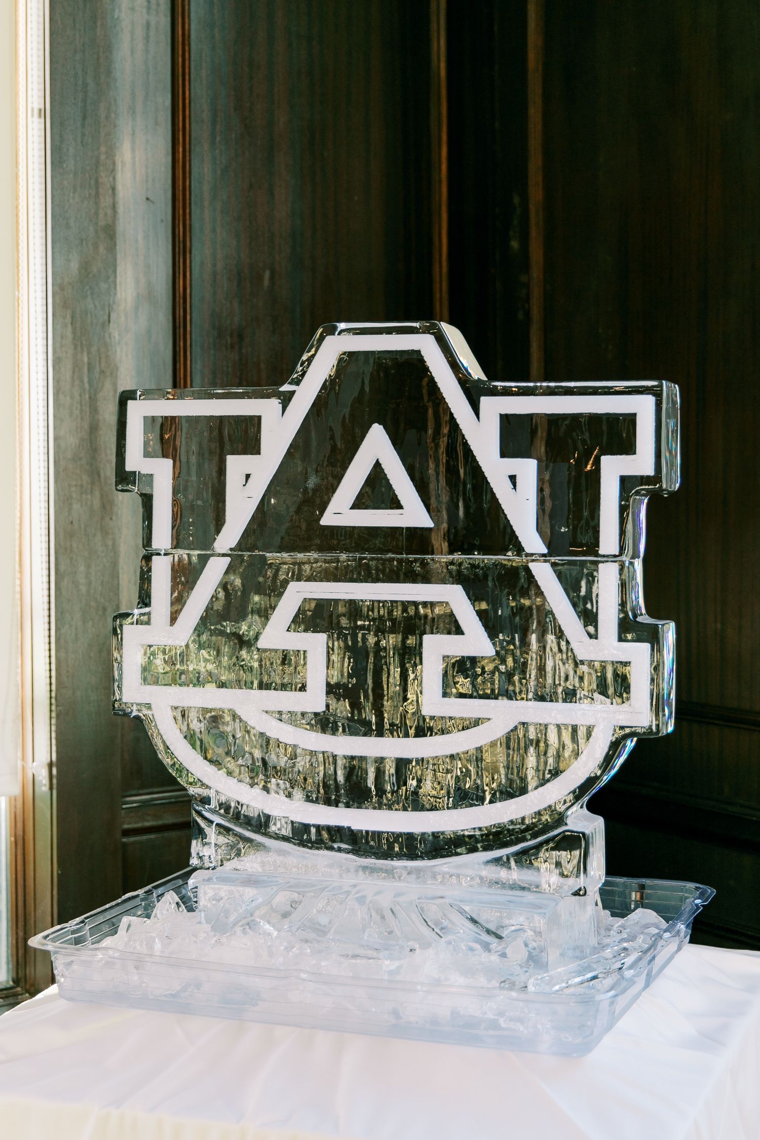 An ice sculpture of the Auburn University logo displayed as an elegant wedding reception decoration.