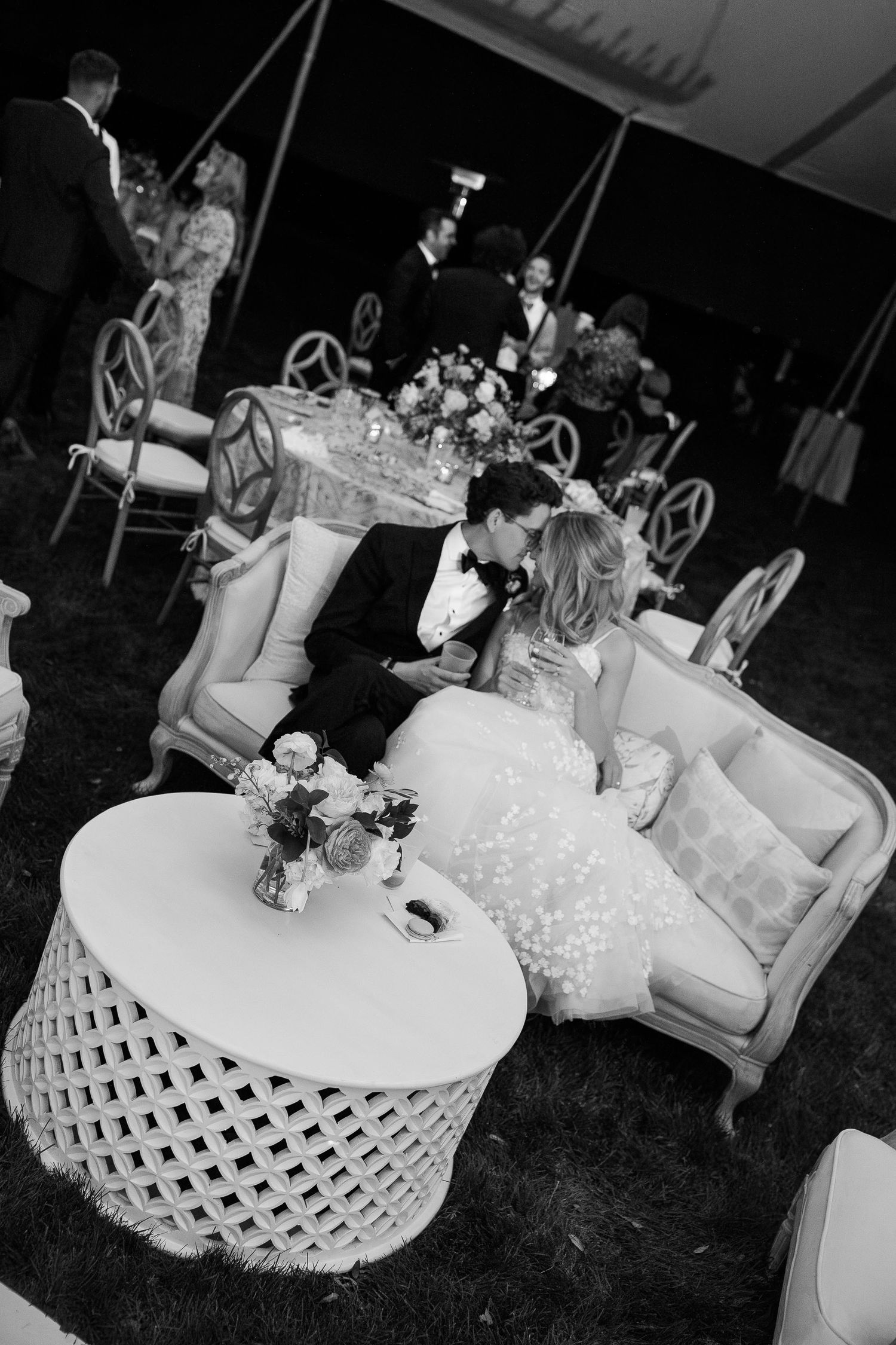 Black and white photo of elegant wedding reception tables with white tablecloths and decorative lattice details.