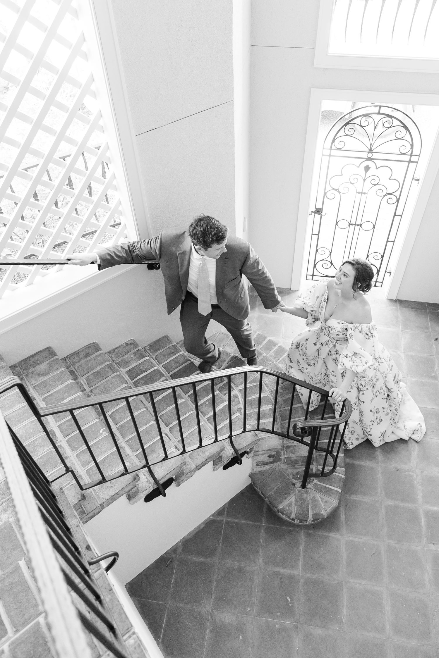 A series of playful poses on an elegant brick staircase with decorative iron railings.